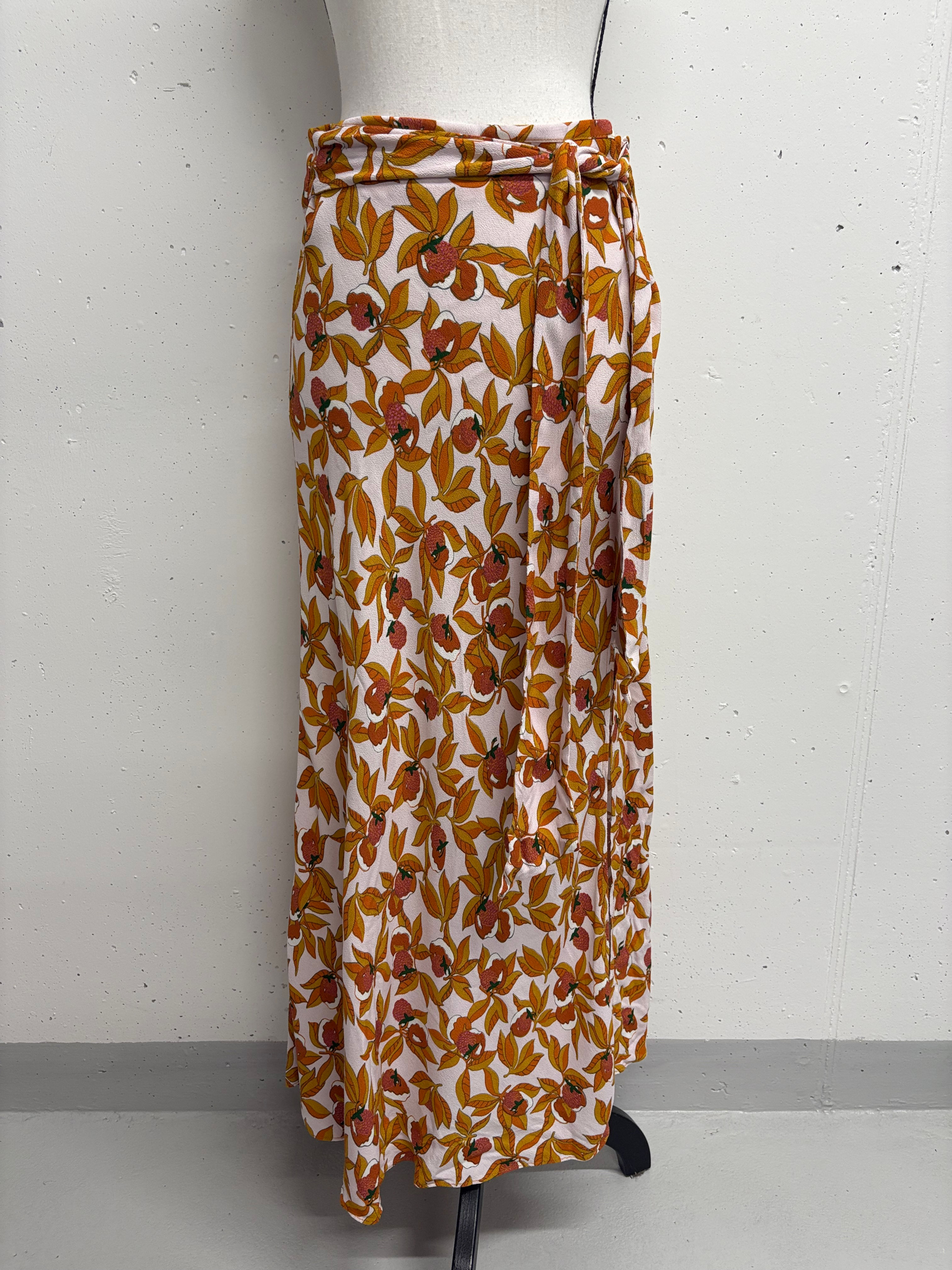 Wickelrock mit Blumenmuster, goldfarbenen Blüten und weißem Hintergrund, Mode.