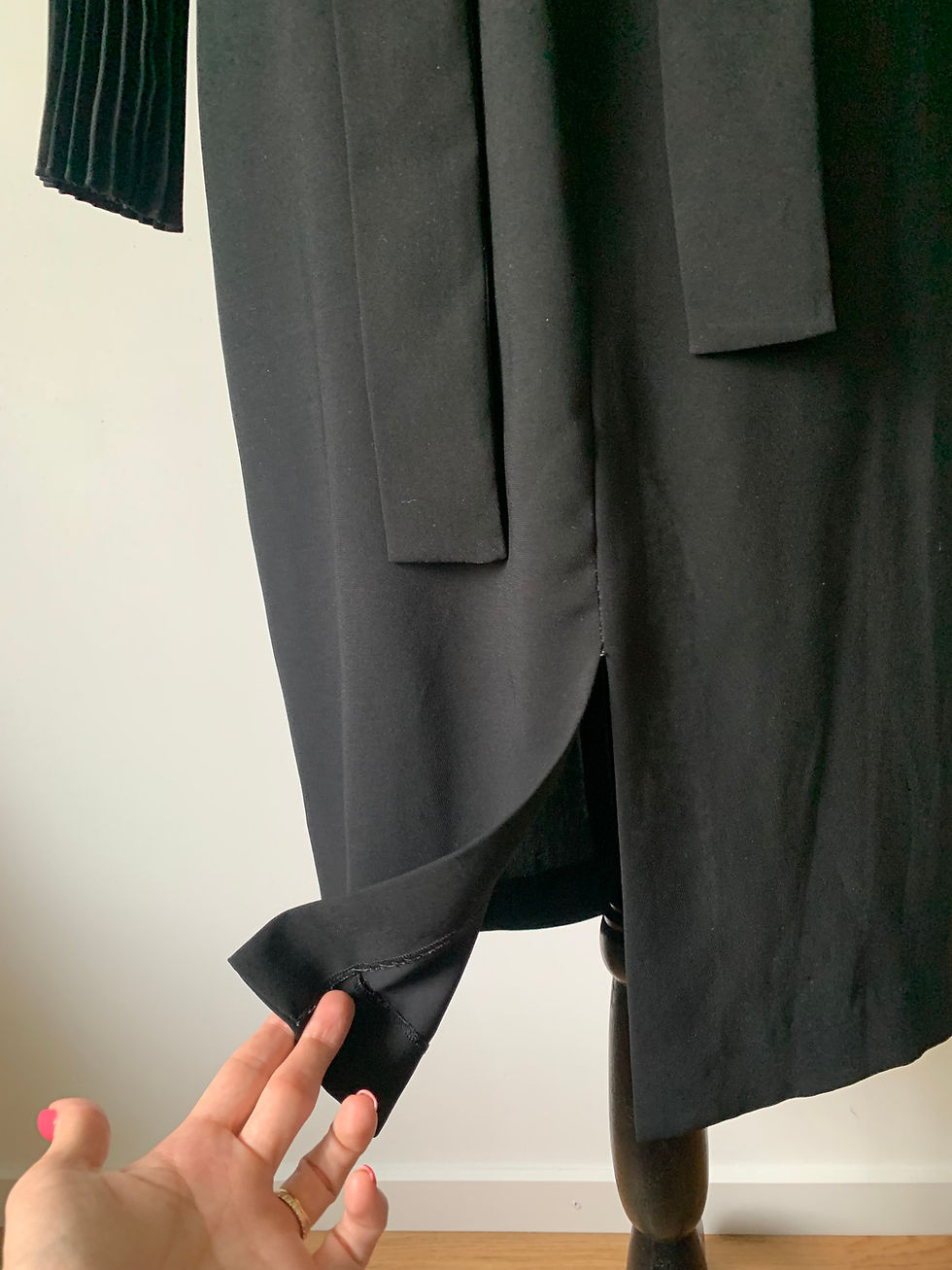 Miniaturbild: Schwarzes Kleid mit Schlitz. Detailaufnahme eines Elegant gekleideten Kleides.