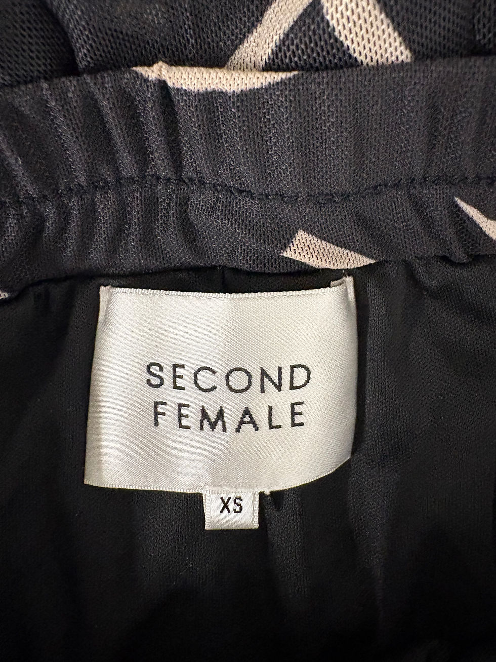 Miniaturbild: Nahaufnahme des Etiketts mit der Aufschrift SECOND FEMALE und Größe XS.