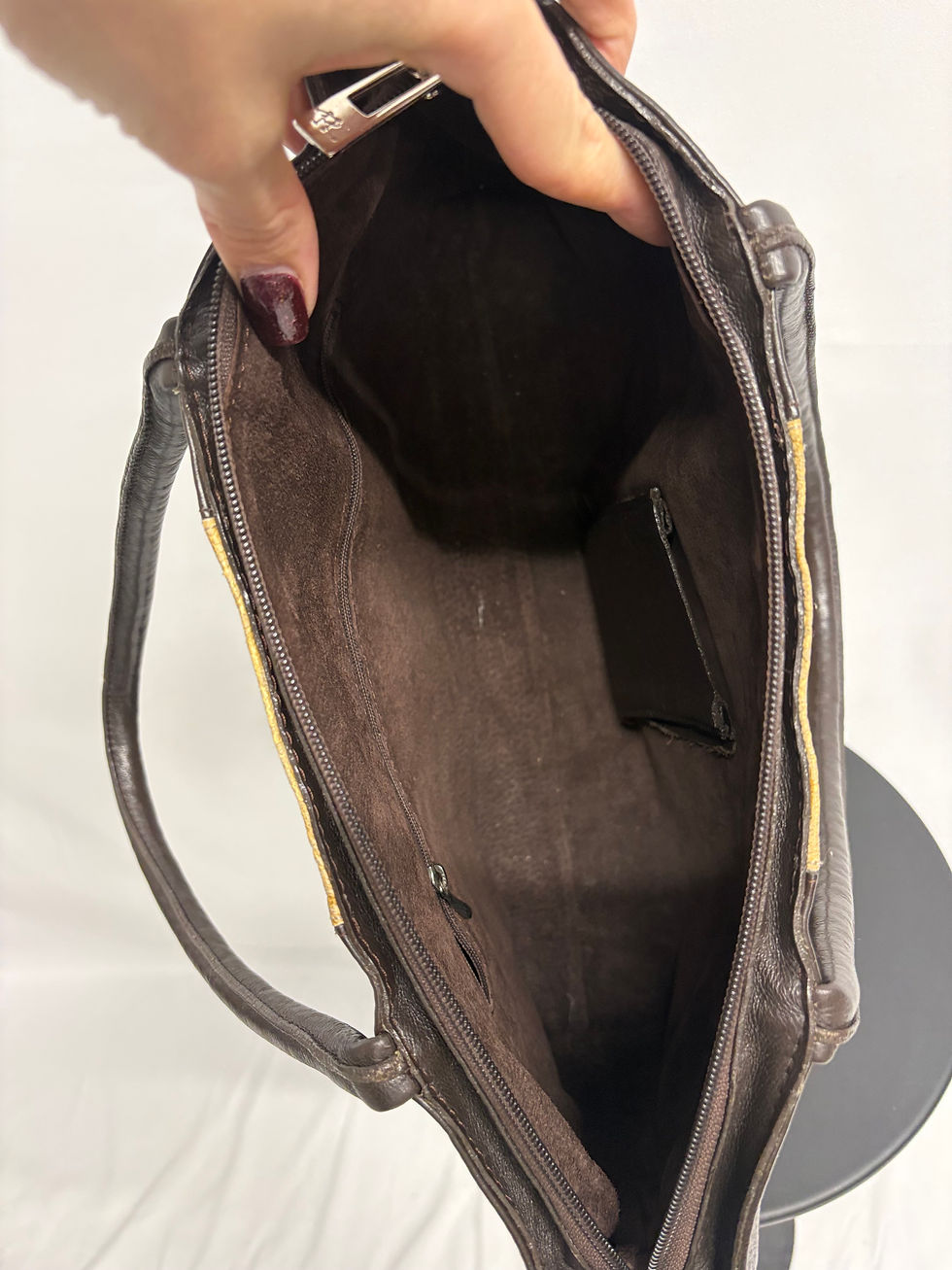 Miniaturbild: Dunkelbraune Ledertasche, offene Ansicht, Innenfutter. Enthält eine kleine Innentasche und Henkel.