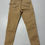 Miniaturbild: Beige Hose mit Reißverschlüssen, Hosenbeine und Taschen auf grauem Untergrund.