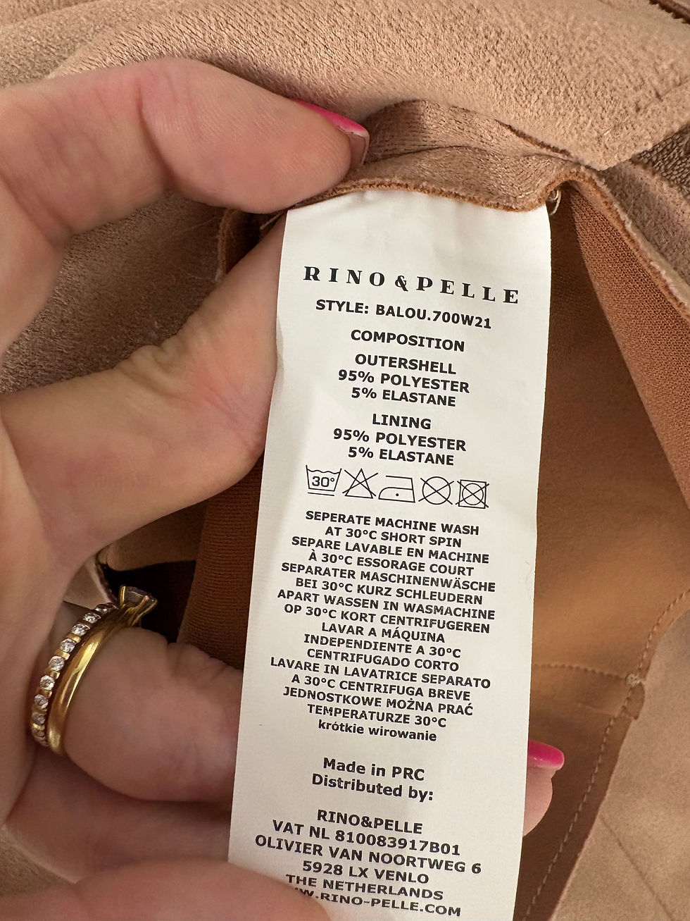 Miniaturbild: RINO & PELLE label with text, composition, care instructions on fabric background.