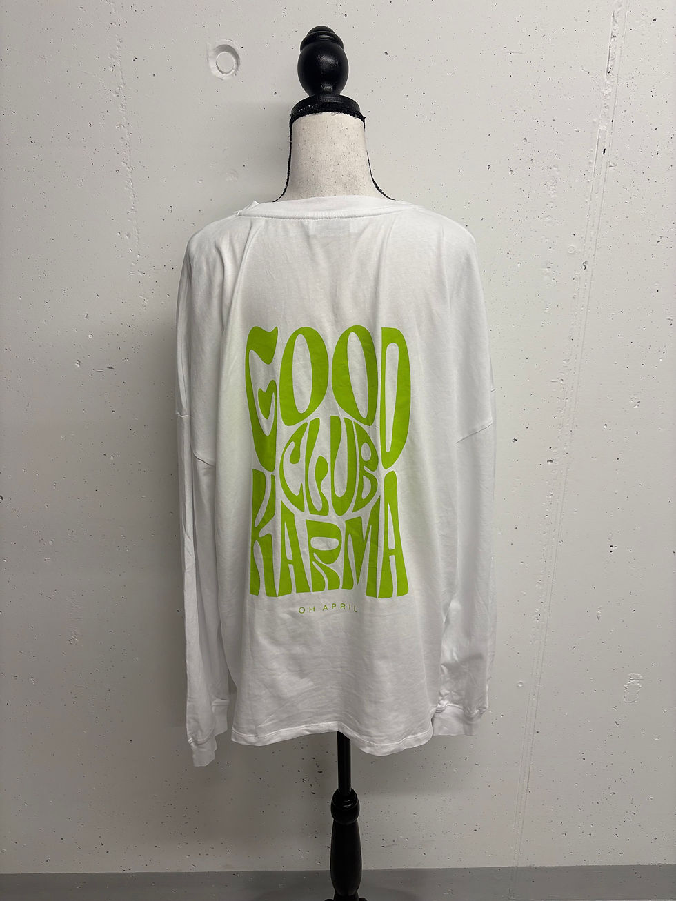 Miniaturbild: Das weiße Shirt mit grünem Text GOOD KARMA vor weißem Hintergrund.