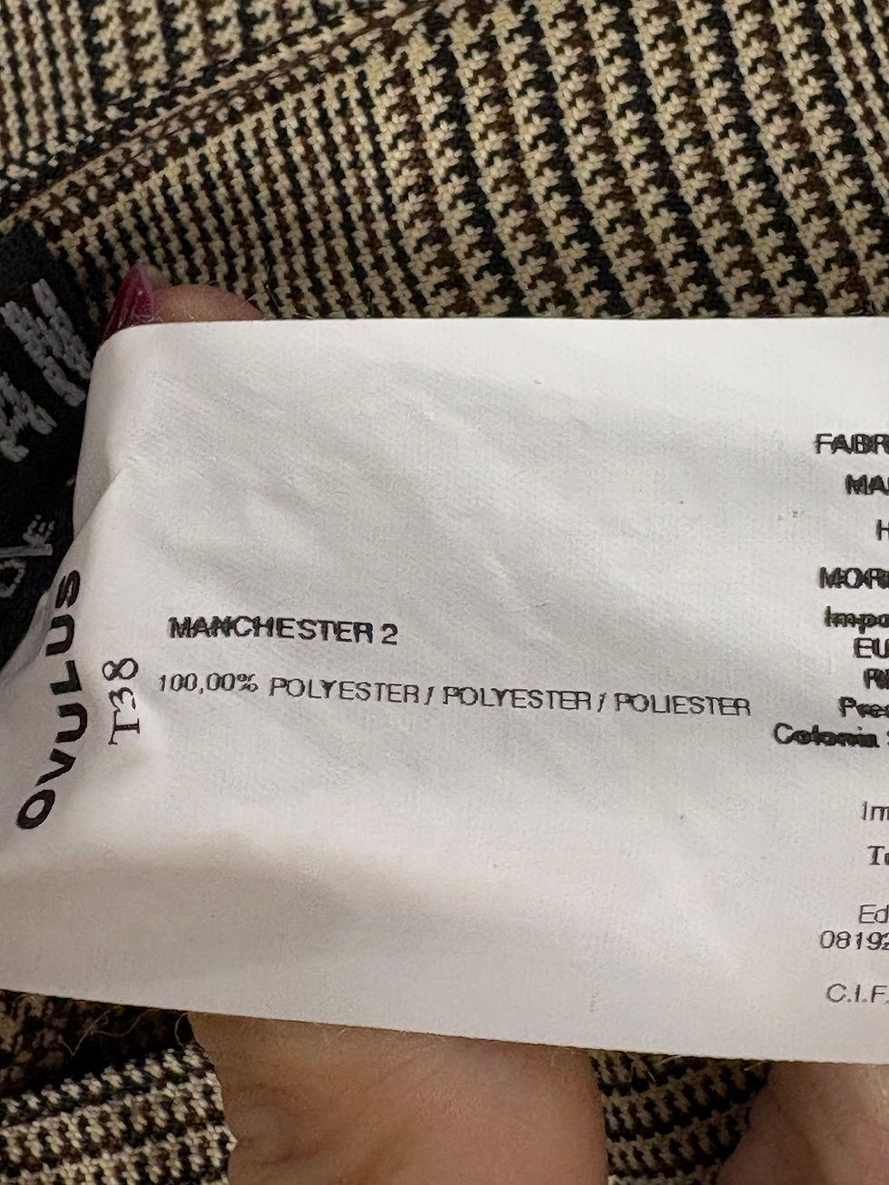 Miniaturbild: Manchester 2 label with text, details polyester, and Ovulus on a fabric background.