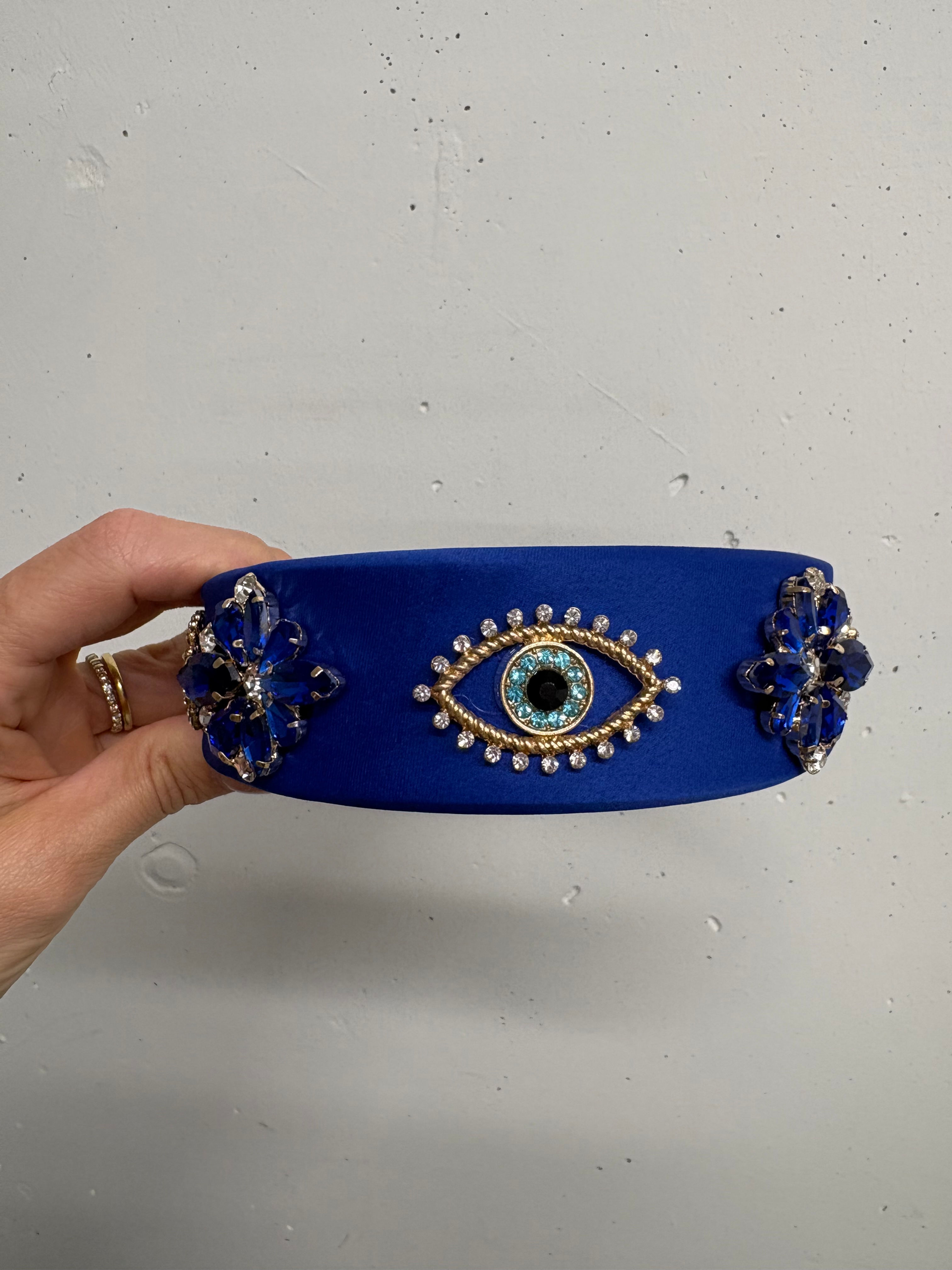 Blaue Stirnband mit Auge Detail. Schmuckstück mit Steinen in einer Hand gehalten.