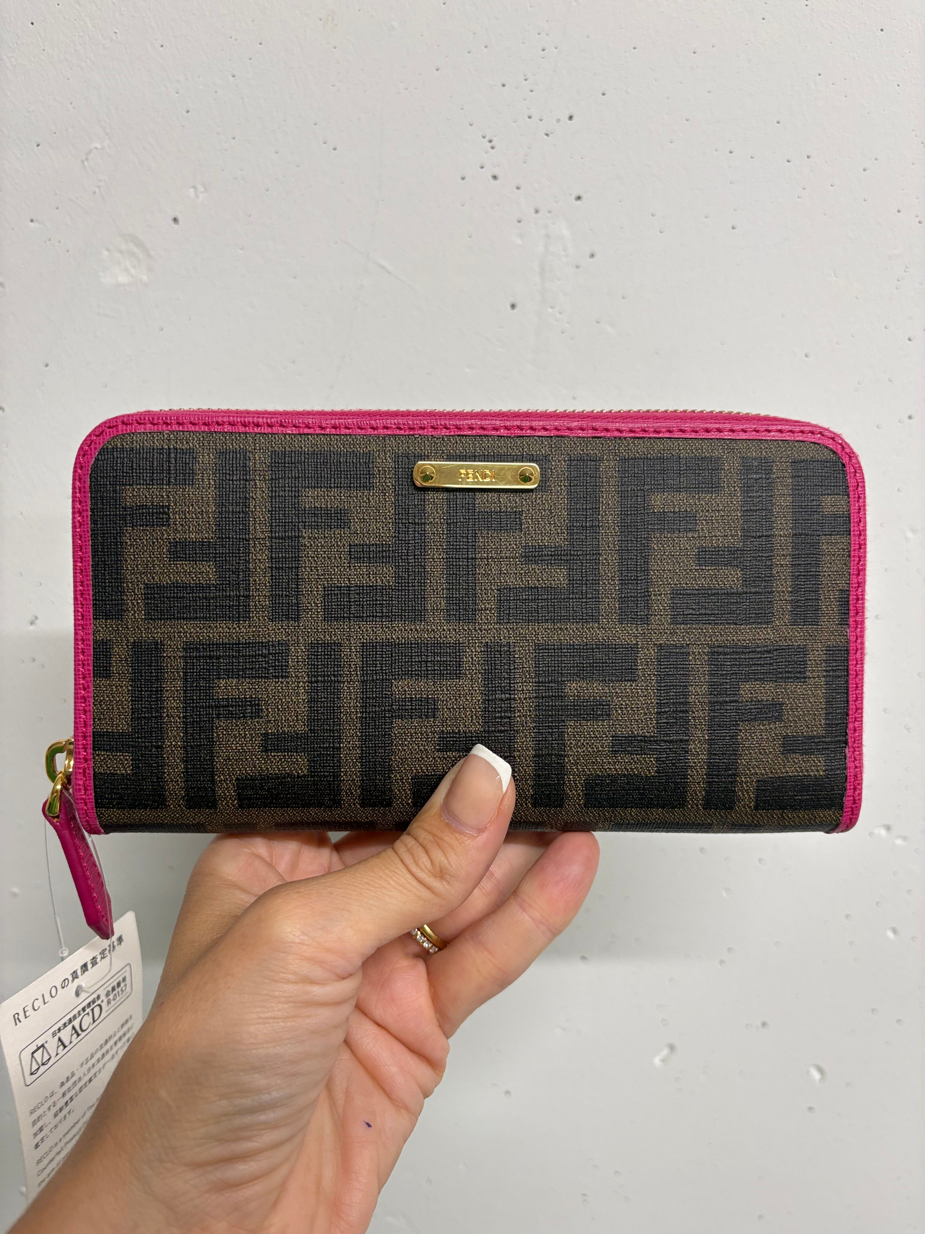 Frauenhand hält FENDI Portemonnaie mit