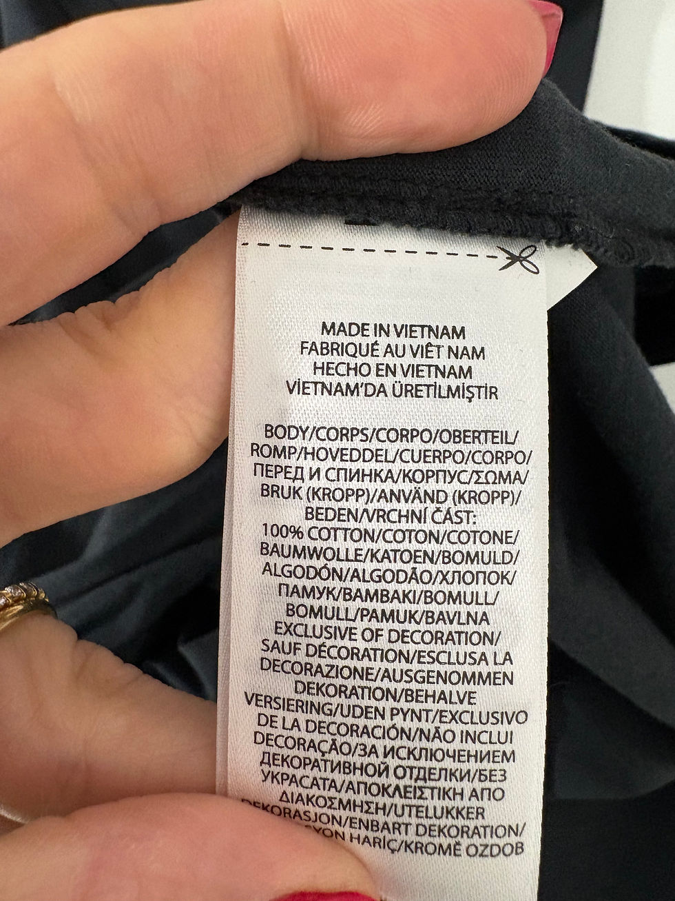 Miniaturbild: Kleidungsetikett mit Aufschrift 'Made in Vietnam' und Materialzusammensetzung in Deutsch.