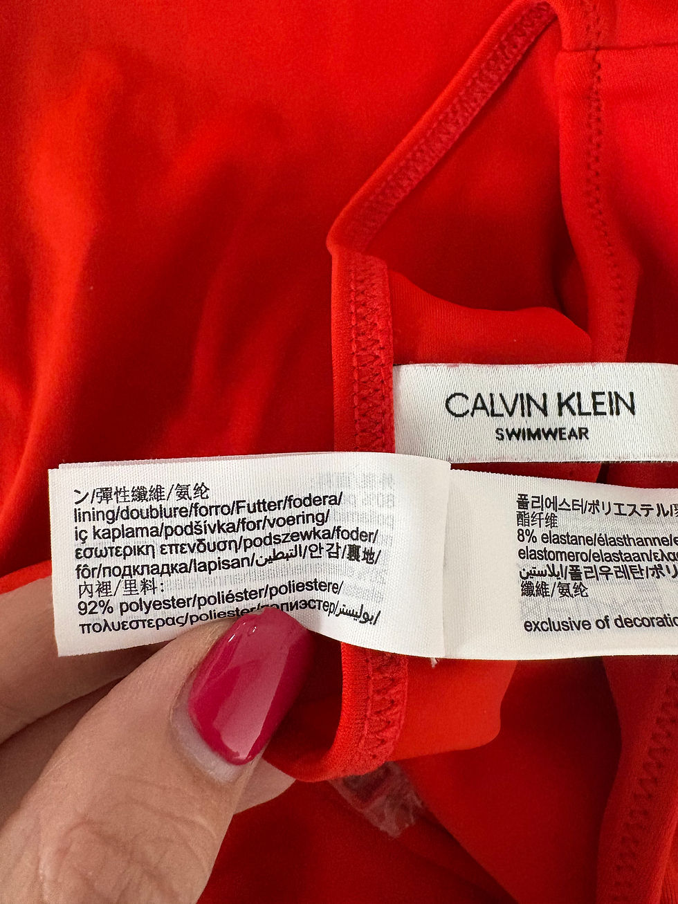 Miniaturbild: Nahaufnahme eines roten Calvin Klein Badeanzugs mit Etiketten im Detail.