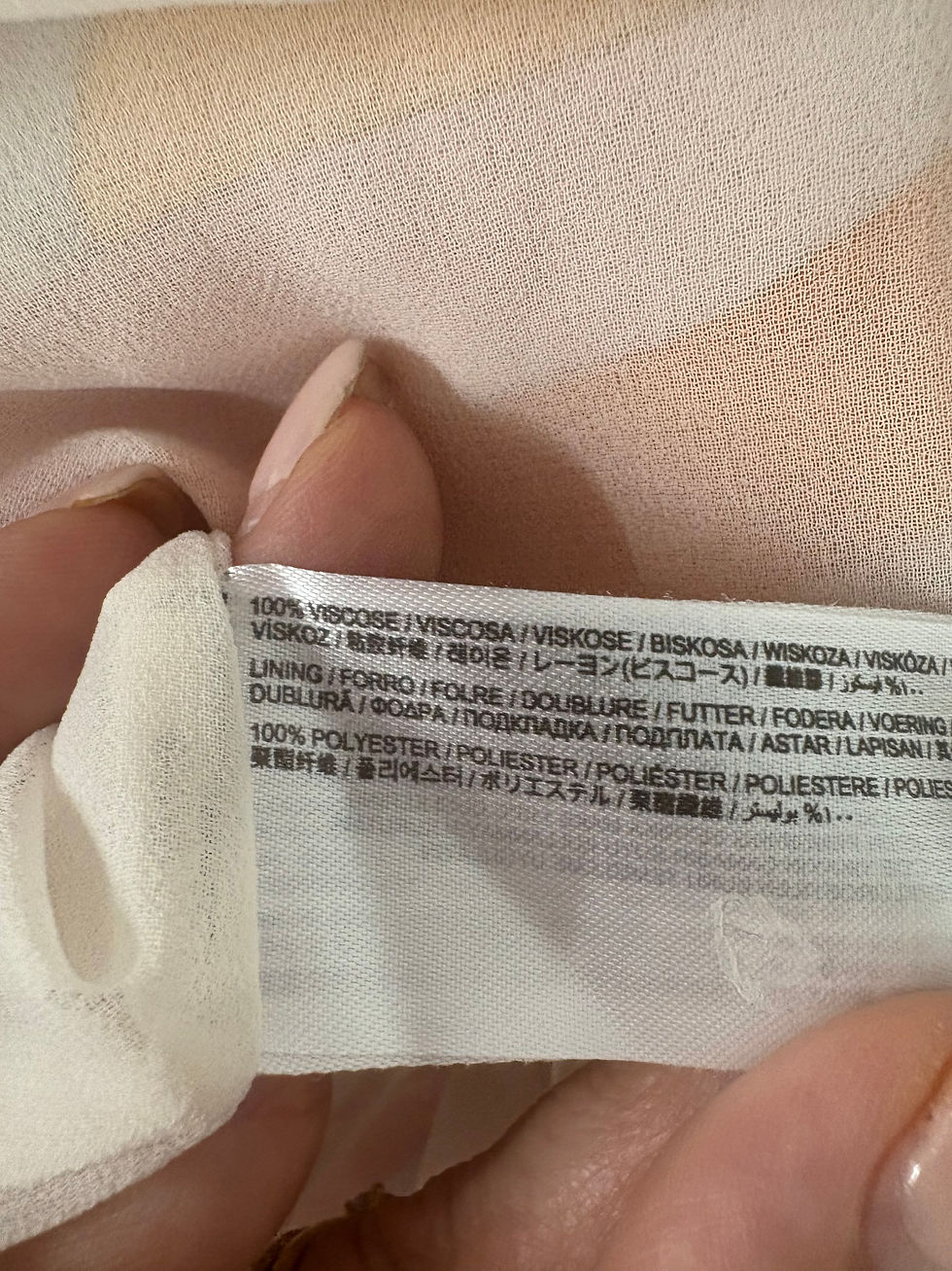 Miniaturbild: Textil-Etikett mit Angaben zu Materialzusammensetzung und Pflegehinweisen. 100% Viskose Textilien.