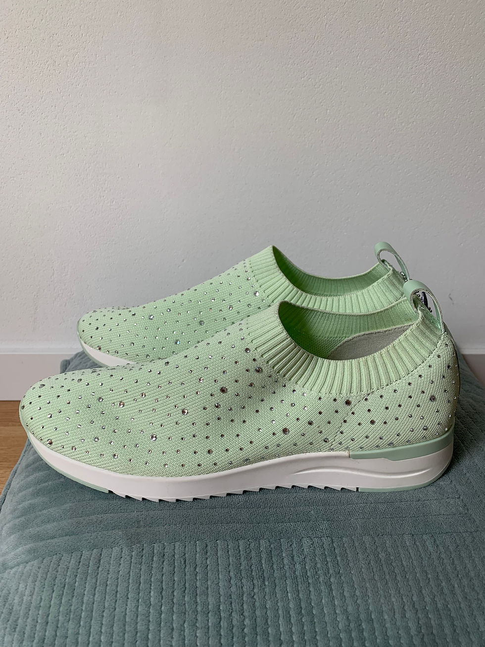 Miniaturbild: Hellgrüne CAPRICE Slipper mit Glitzersteinen Gr. 40 auf einem blauen Kissen in Nahaufnahme