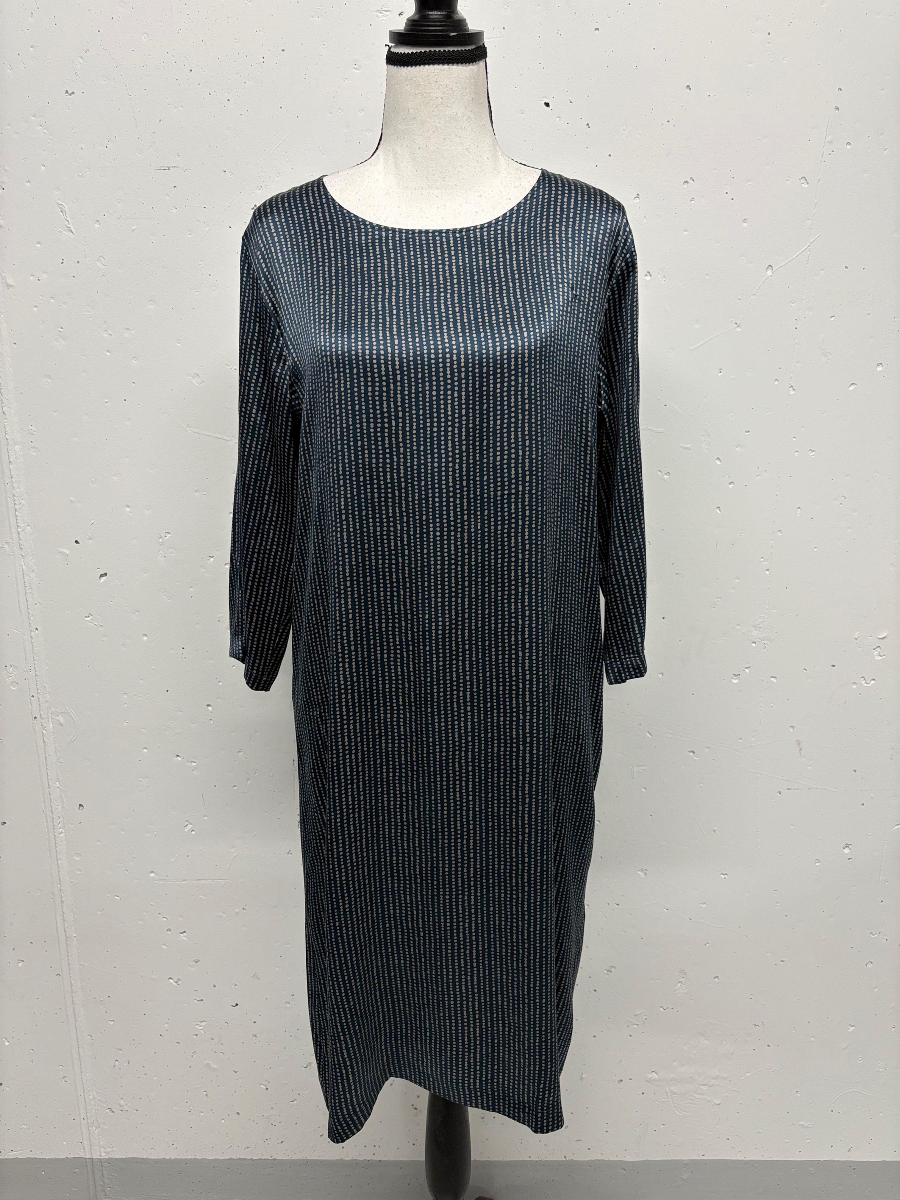 Dunkelgraues Kleid, gerader Schnitt, mit langen Ärmeln auf Schaufensterpuppe vor hellem Hintergrund.