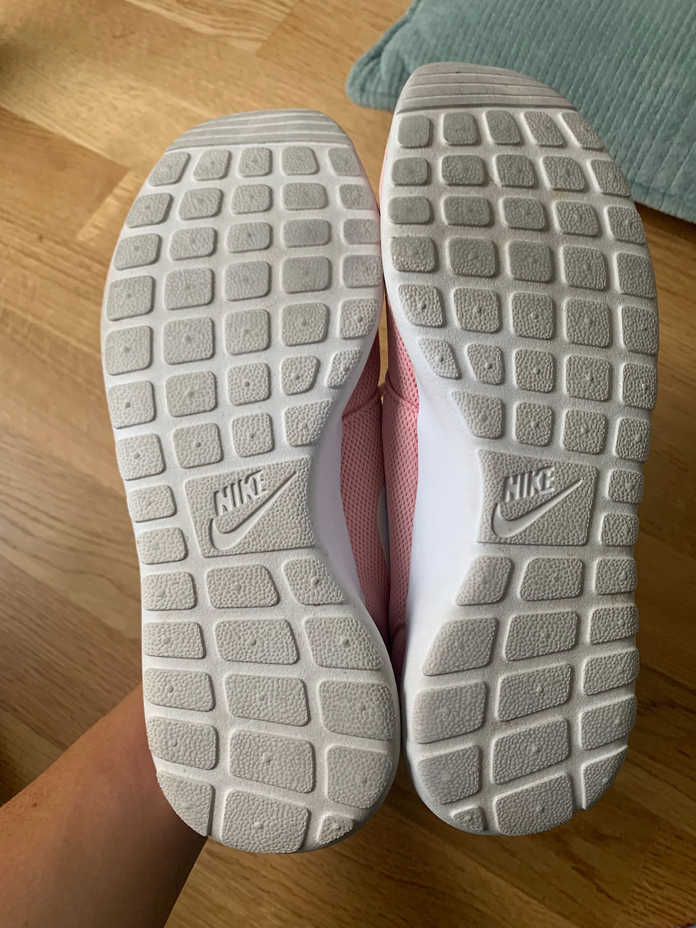 Miniaturbild: Nahaufnahme der Sohle eines rosa Nike-Schuhs mit dem Nike-Logo.
