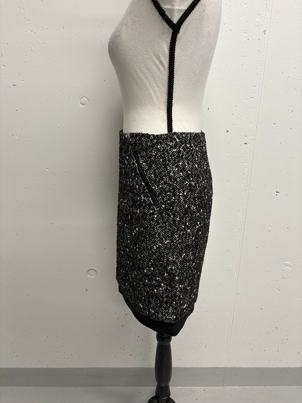 Miniaturbild: Dunkelgrauer Tweed-Bleistiftrock auf Schneiderpuppe vor weißem Hintergrund.
