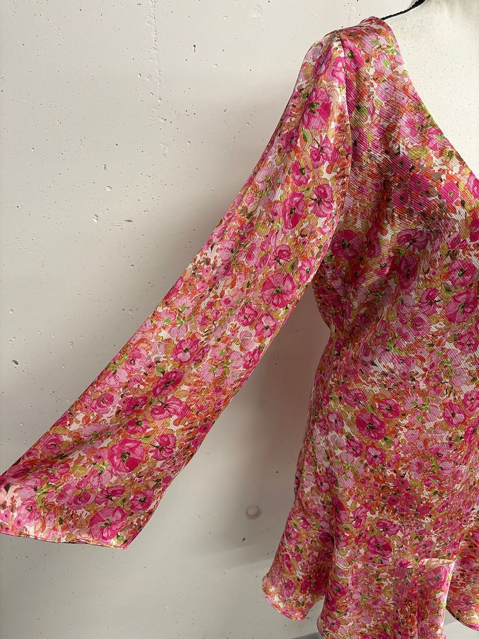 Miniaturbild: Damenbekleidung, rosafarbenes Blumenmuster-Oberteil, Detailaufnahme, leichter Stoff, Sommerkleidung, Ärmel.