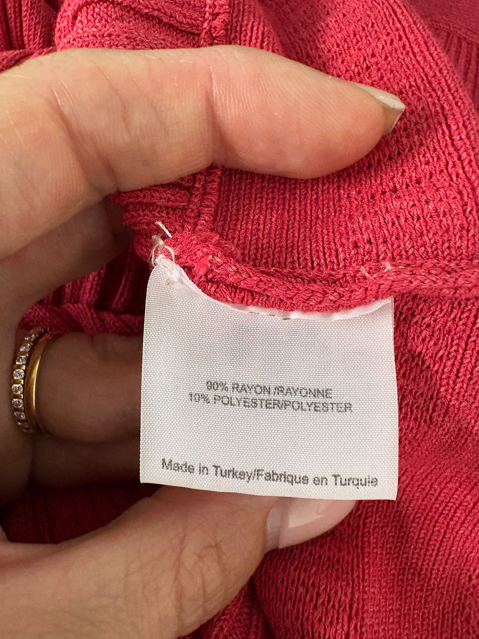 Miniaturbild: Etikett mit Text zeigt 90% Rayon, 10% Polyester, Made in Turkey. Stoffdetails.