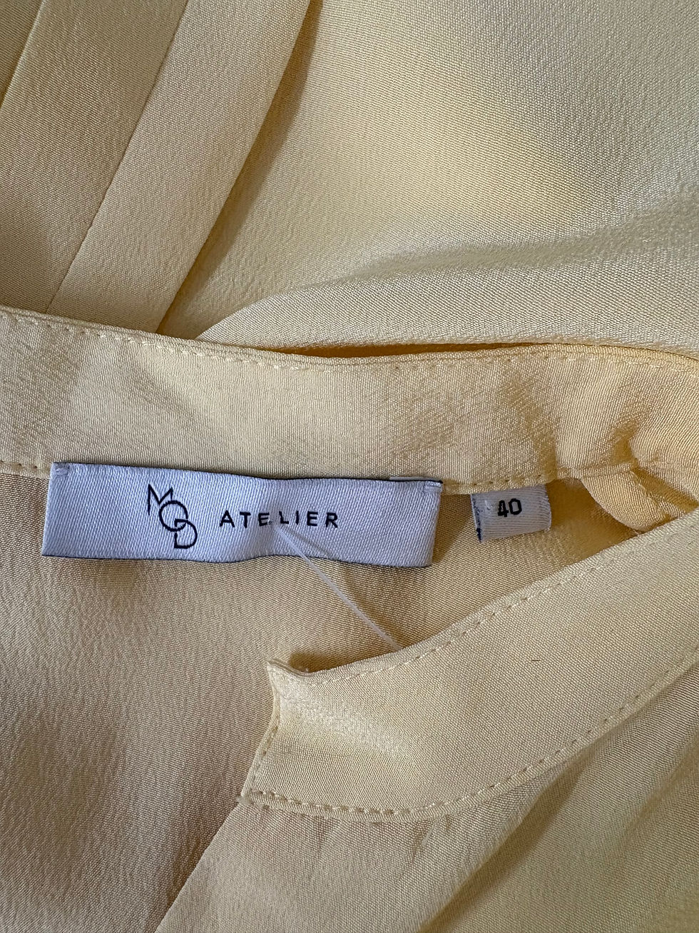 Miniaturbild: Gelbe Bluse mit Etikett: MCQ ATELIER, Größe 40, Nahaufnahme, leichte Falten