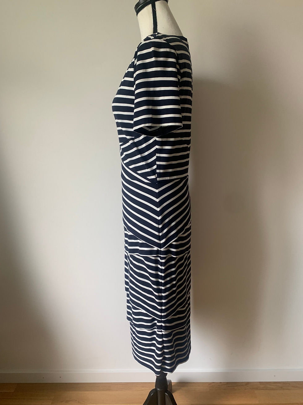 Miniaturbild: Dunkelblau-weiß gestreiftes Kleid, seitlich stehend, mit V-Ausschnitt, elegante Sommer Mode.