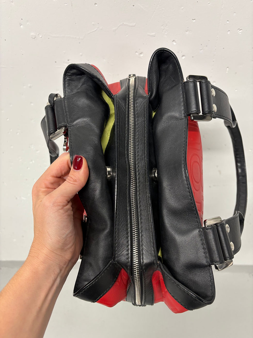 Miniaturbild: Hand hält eine offen, rote und schwarze Handtasche, Reißverschluss Detail nah