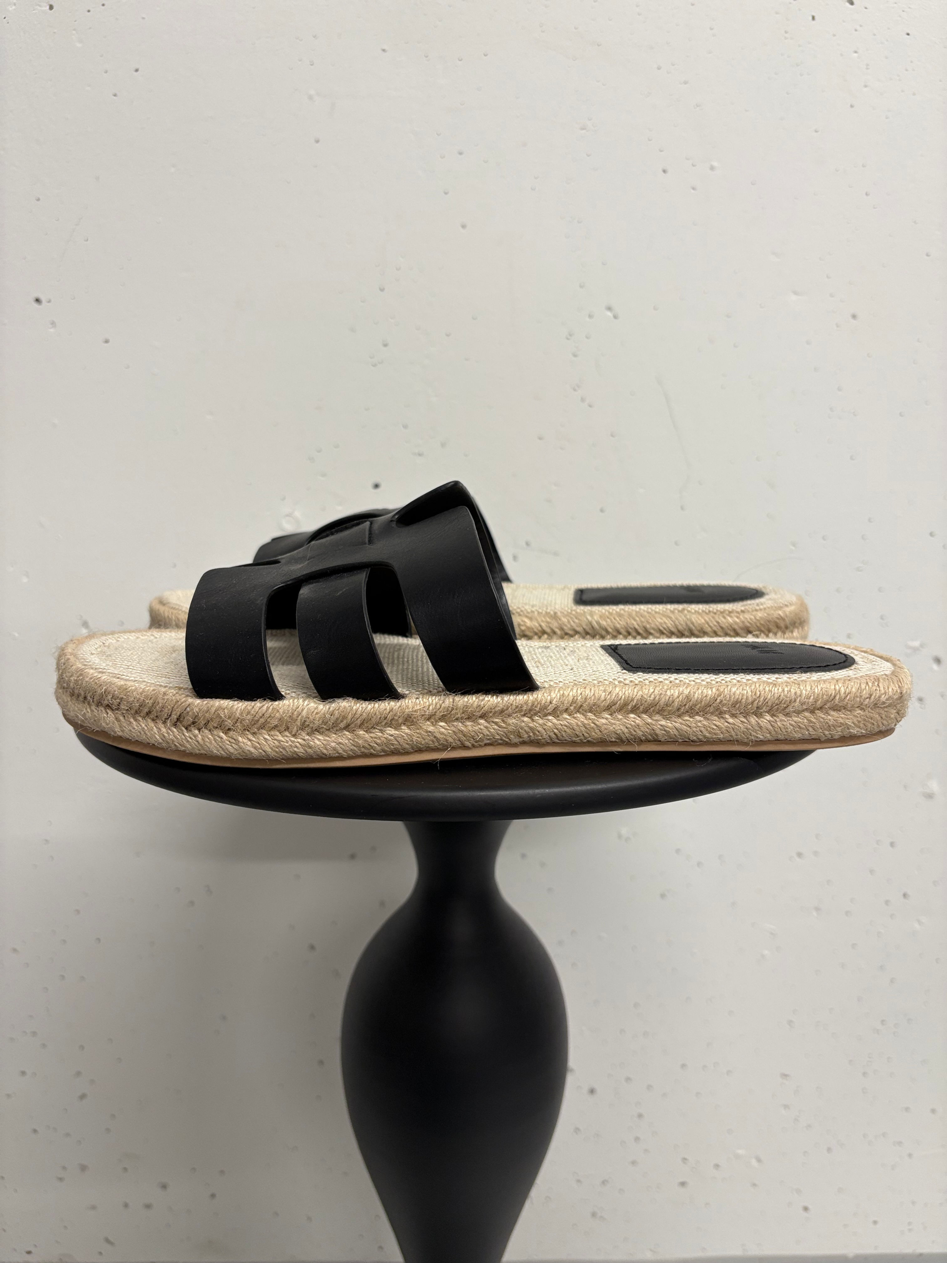 Schwarze Sandalen auf einem kleinen Tisch, Mode-Accessoire, stilvoll und schick.