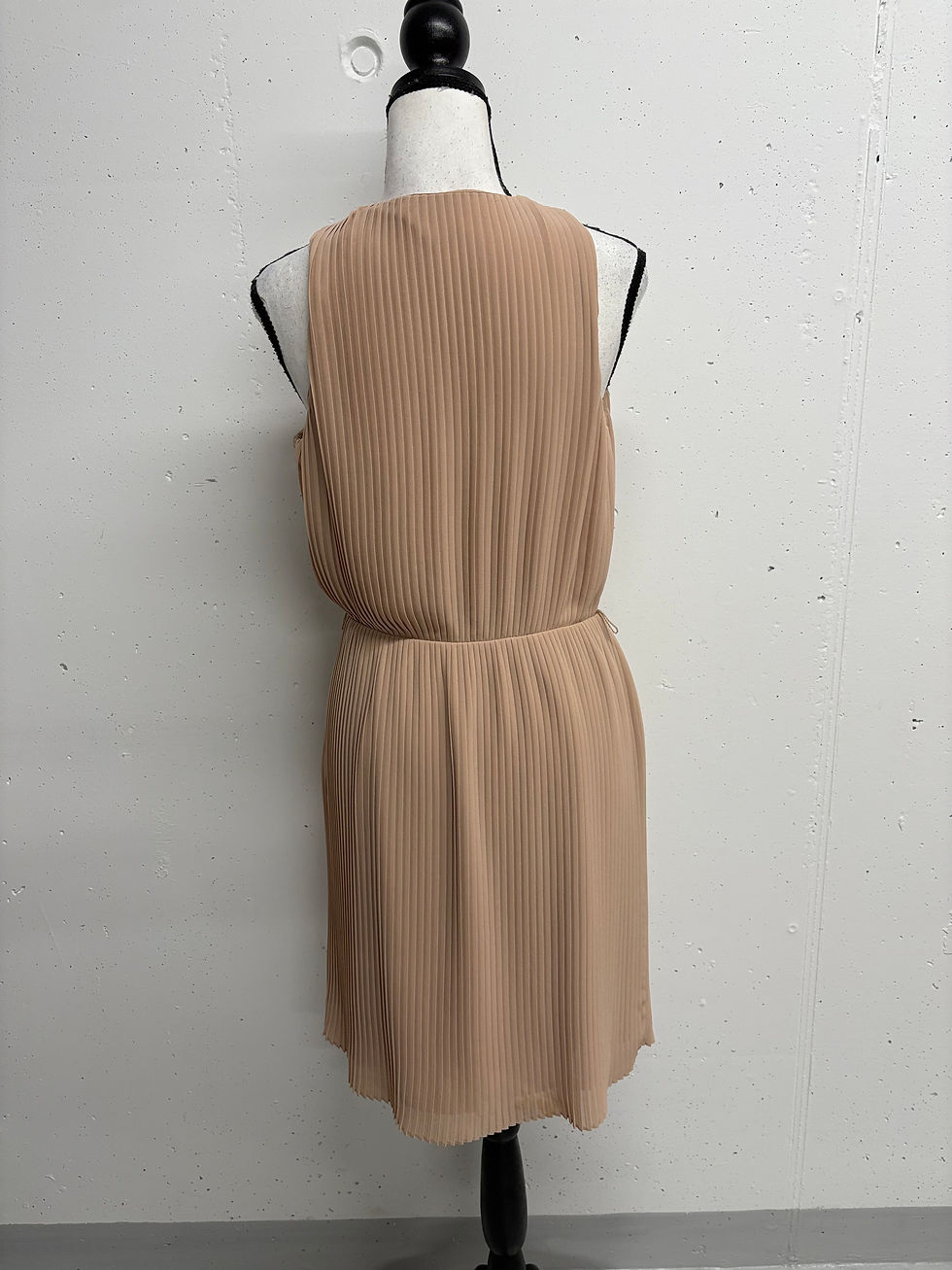 Miniaturbild: Beige Kleid auf der Mannequin-Rückseite, elegante Mode im Atelier.