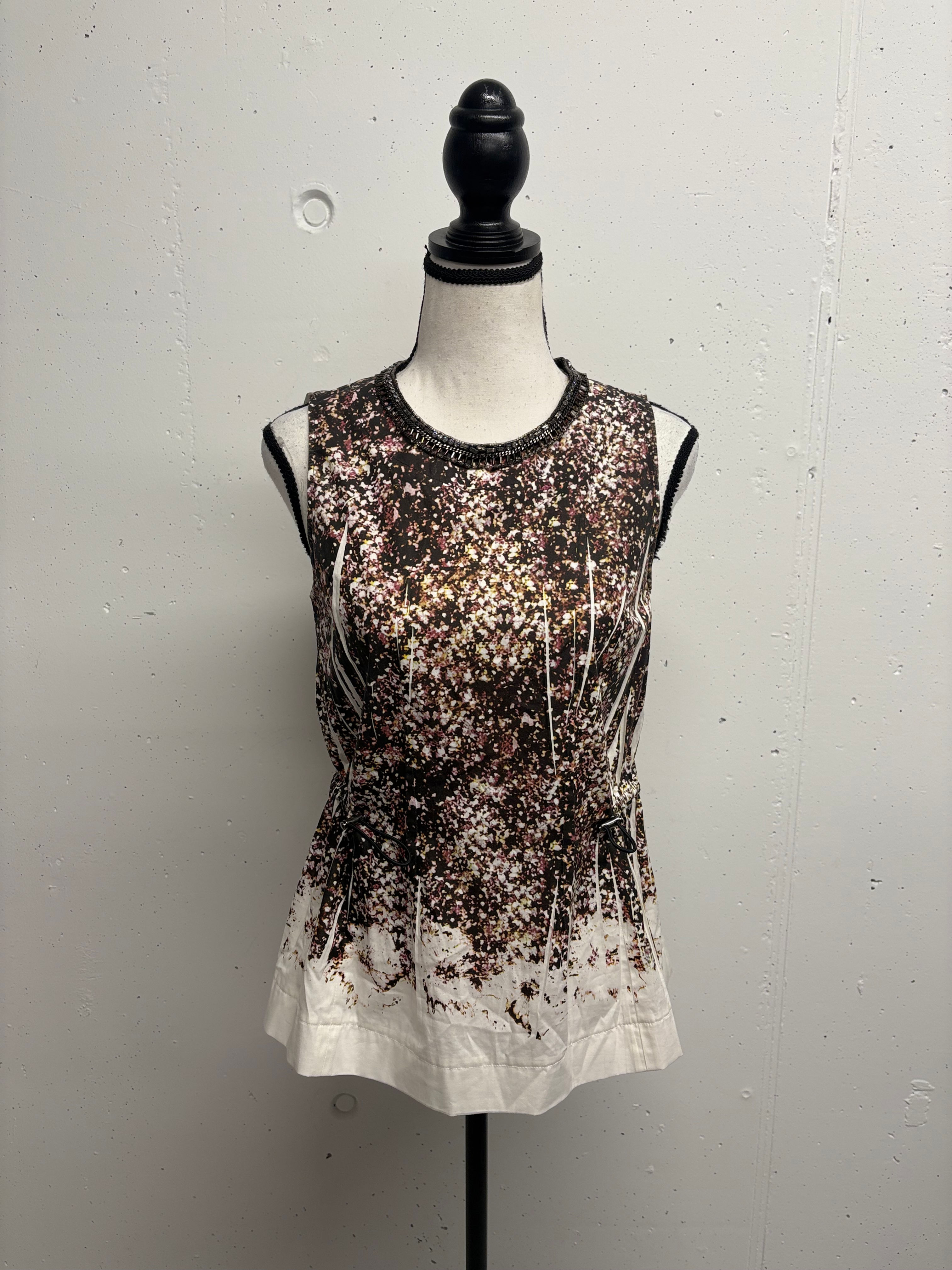 Damen-Top mit floralem Muster auf einem Schaufensterpuppe vor weißem Hintergrund.