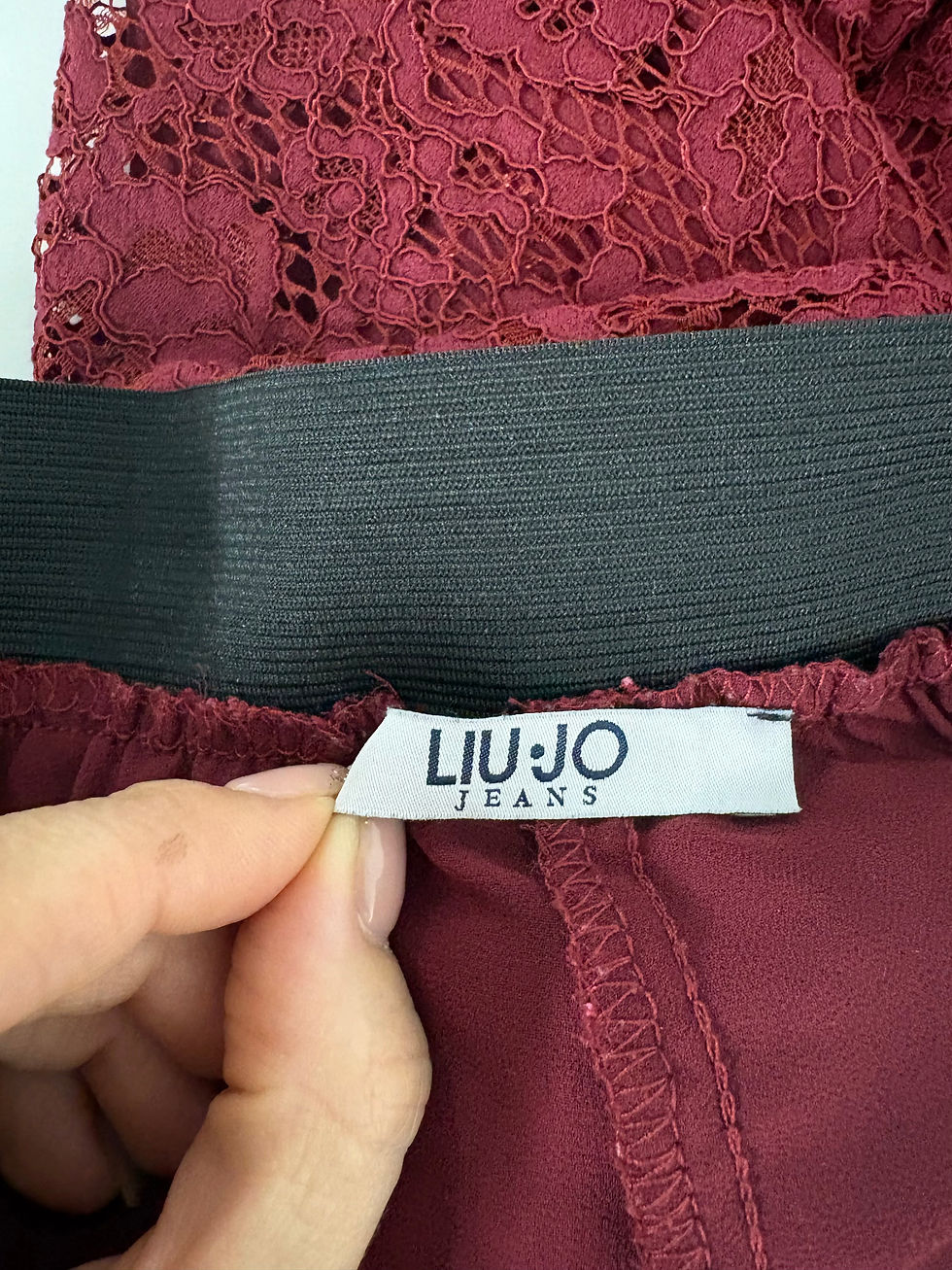Miniaturbild: Nahaufnahme eines roten Rockes mit LIU JO Jeans Etikett, Textil Details.