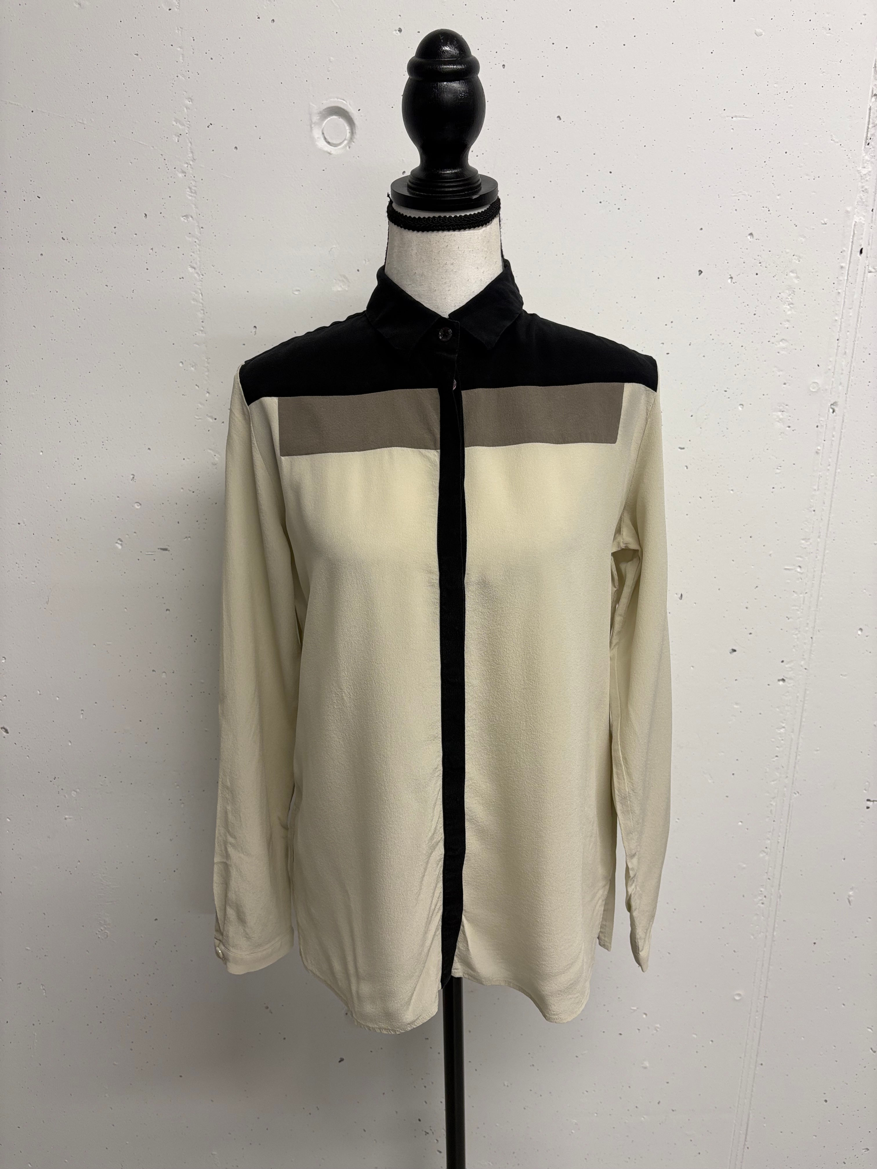 Beige Hemd mit schwarzen und grauen Details, auf einem Schaufensterpuppen.