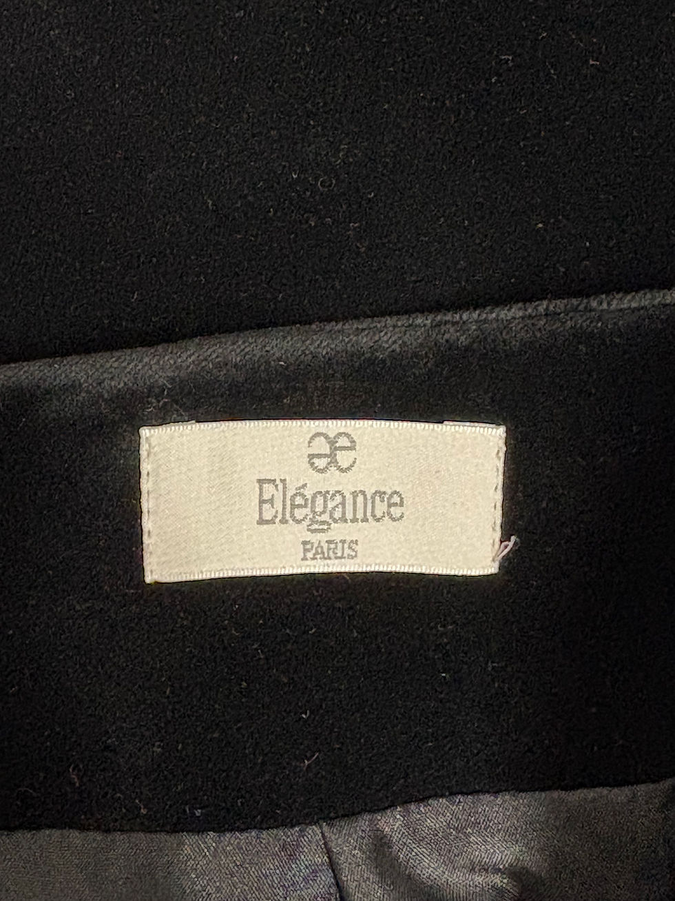 Miniaturbild: Nahaufnahme eines Etiketts mit dem Text „Élégance PARIS“ auf Schwarz.