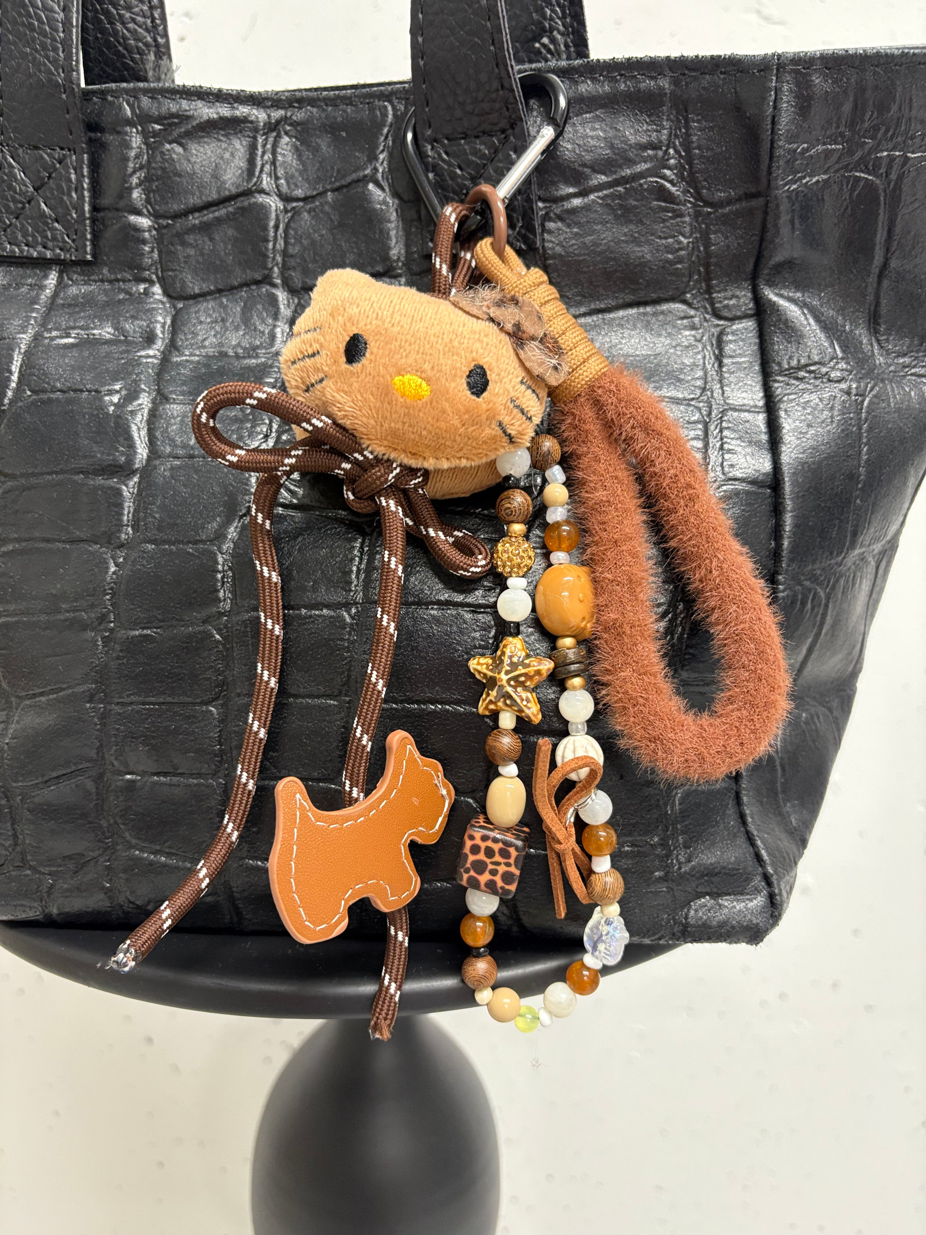 Schwarze Tasche mit Hello Kitty, Hund und Schmuckanhänger