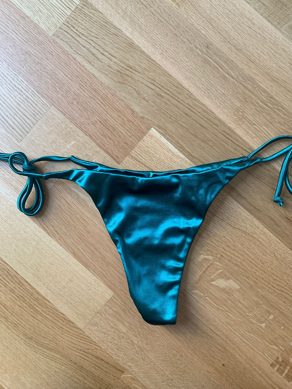 Miniaturbild: Türkisfarbener Bikini-Slip auf Holzuntergrund, glänzend, elegant, Sommer-Outfit.