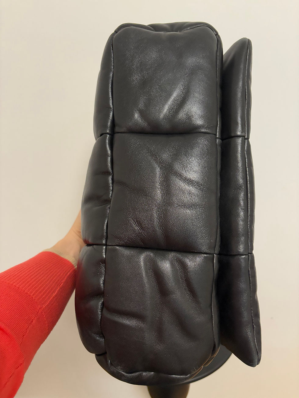 Miniaturbild: Schwarze gesteppte Ledertasche in der Hand gehalten, stilvolles Accessoire, Fashion Statement.