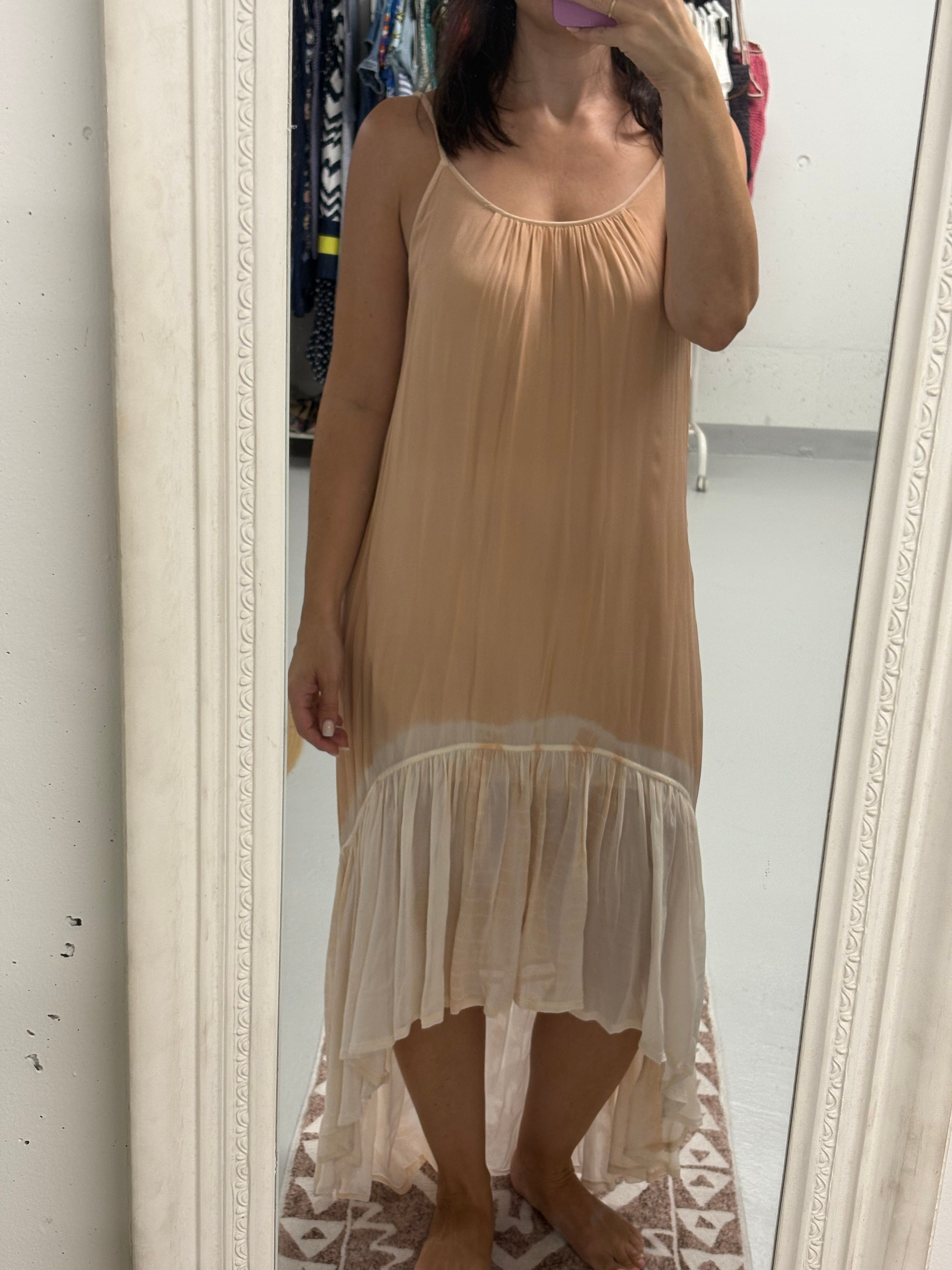 Frau trägt ein beigefarbenes Kleid vor einem Spiegel. OPUS knielanges Kleid Gr. 34.