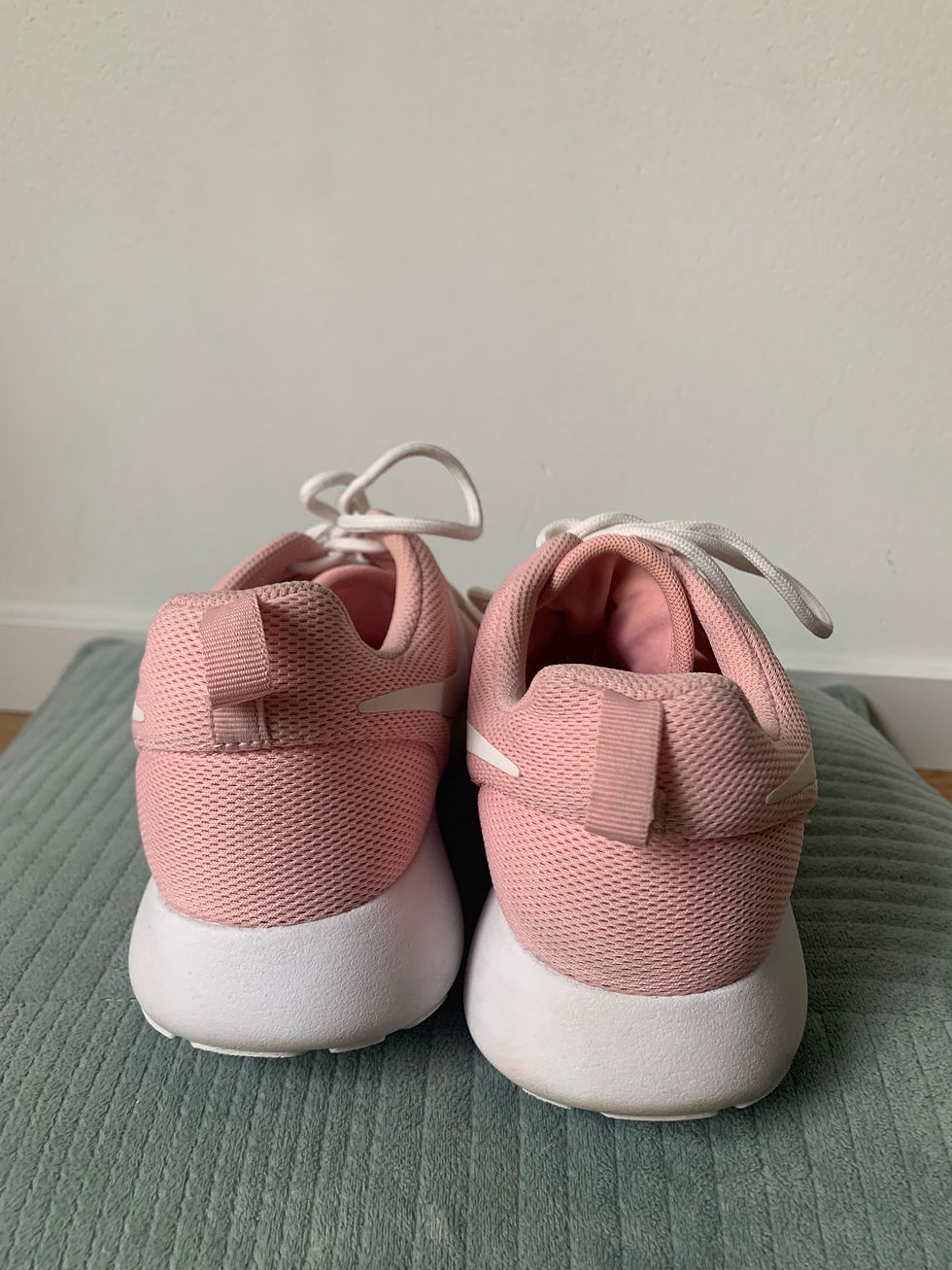 Miniaturbild: Zwei rosa Turnschuhe vor hellem Hintergrund stehen auf einer grünen Matte.