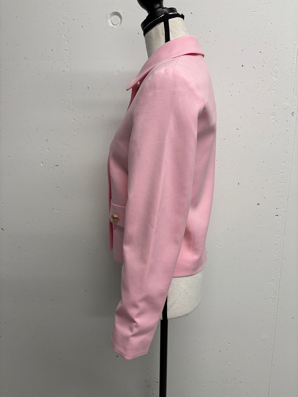 Rosa Jacke, seitliche Ansicht, mit Knöpfen. Modeartikel in einem neutralen Studio.