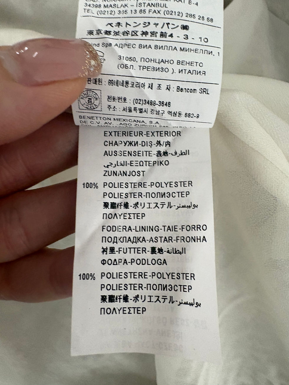 Miniaturbild: Das Etikett zeigt Text von außen; 100% Polyester Stoff. Details von Italien.
