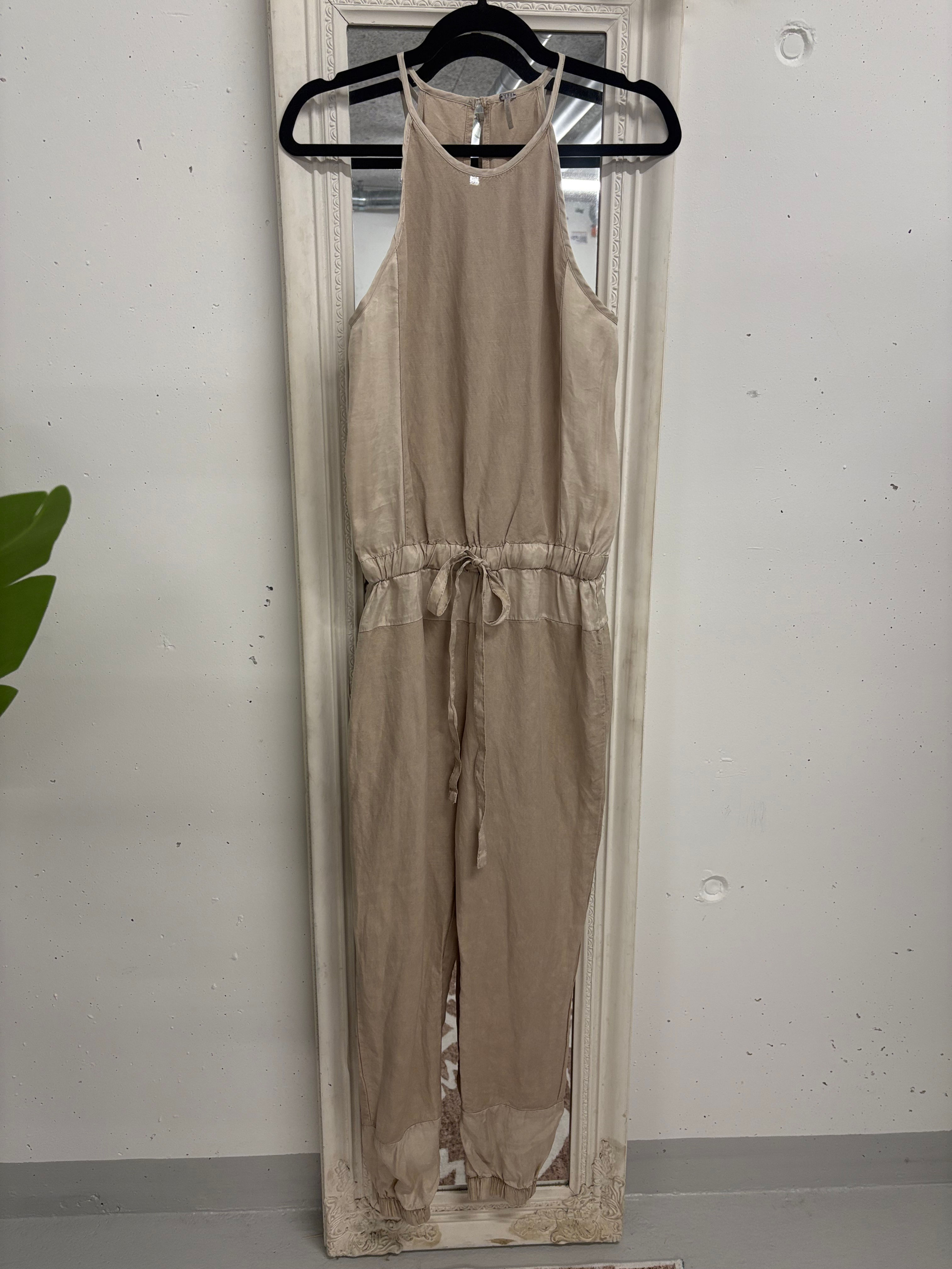 Beiger Overall mit Kordelzug vor Spiegel. Schlichtes Outfit für jeden Anlass.