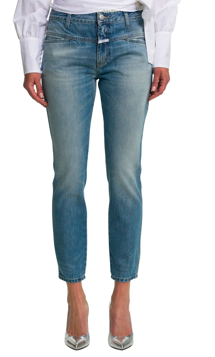 Frau trägt blaue Jeans; eng anliegend, vor weißem Hintergrund. Modisch und modern.