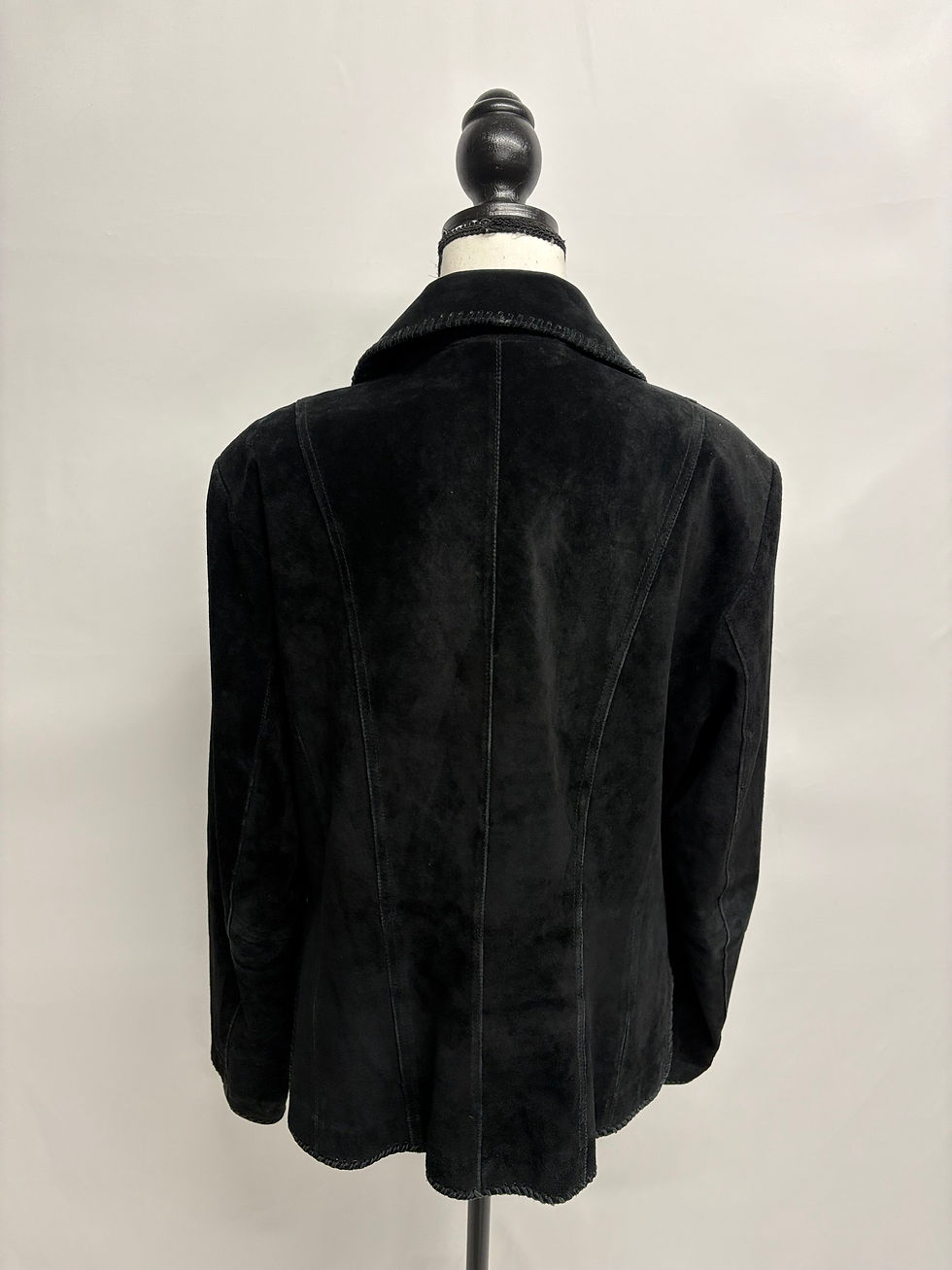 Miniaturbild: Schwarze Wildlederjacke auf einem Büstenhalter, Rückseite; Mode-Highlight im Detail.