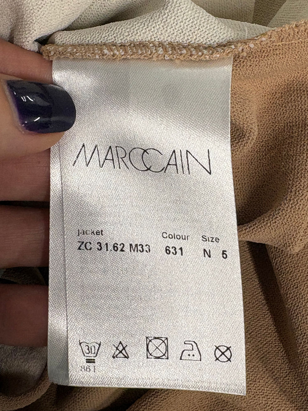Miniaturbild: MARCCAIN label with jacket details and size information, beige fabric background.