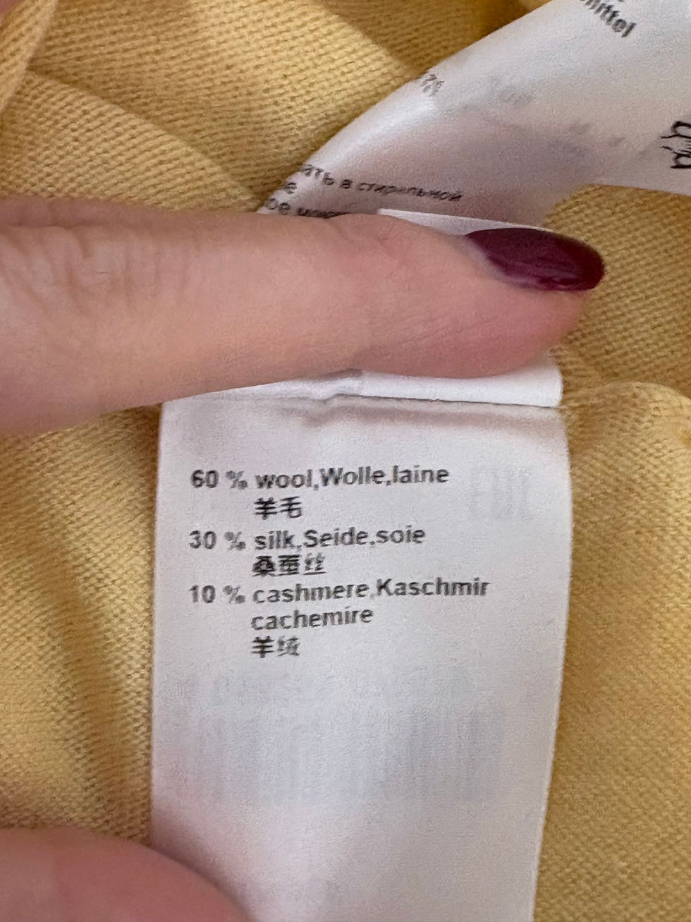 Miniaturbild: White clothing tag with text: 60% wool, 30% silk, 10% cashmere.