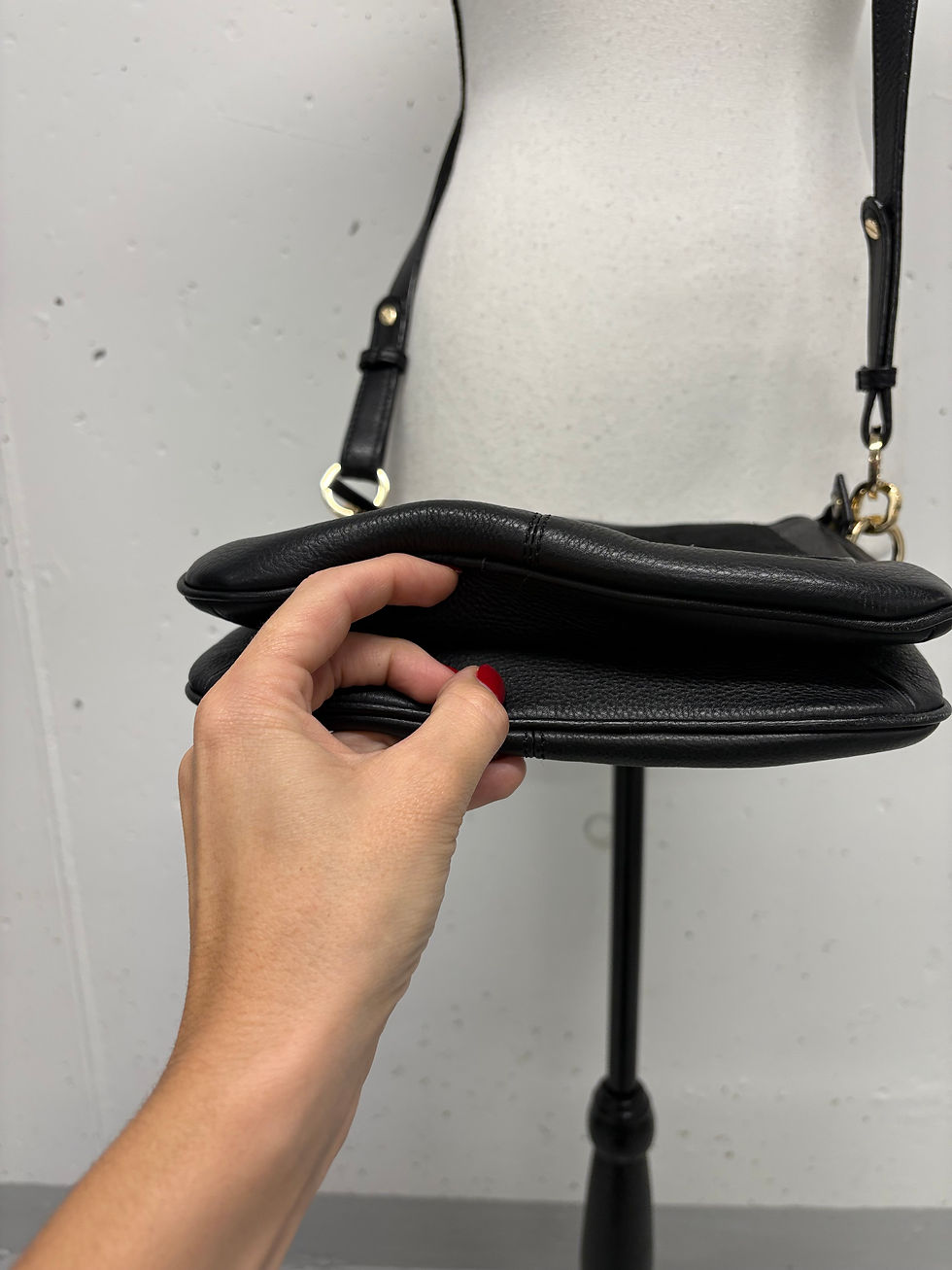 Miniaturbild: Schwarze Handtasche mit Frau Hand. Offene Tasche mit leerem Fach Detail.