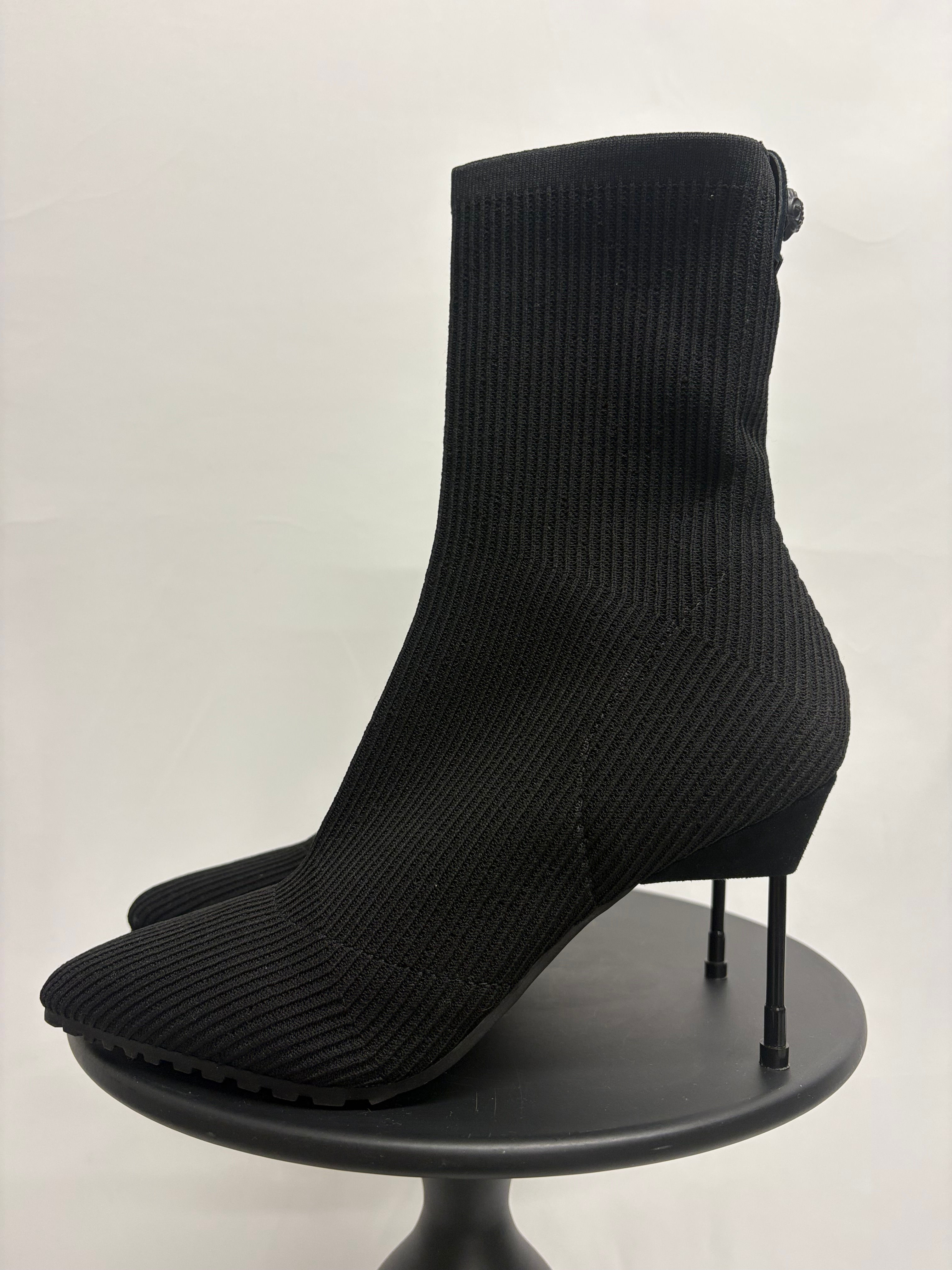 Schwarze Stiefelette mit spitzem Absatz auf einem Präsentationsständer. Stilvolle Mode.