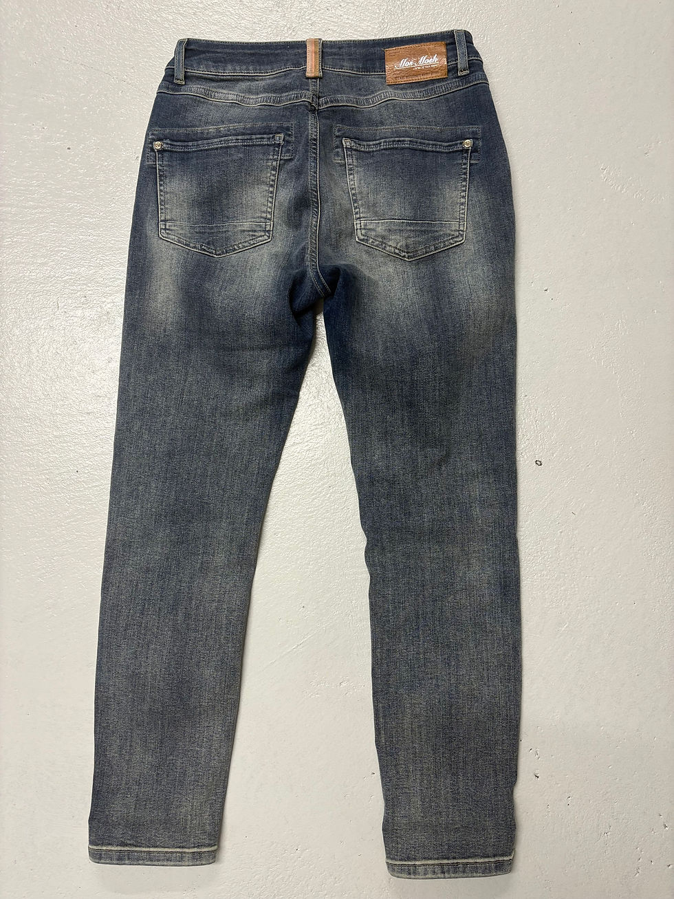 Miniaturbild: Dunkelblaue Jeans von hinten. Blaue Jeans auf hellem Hintergrund.