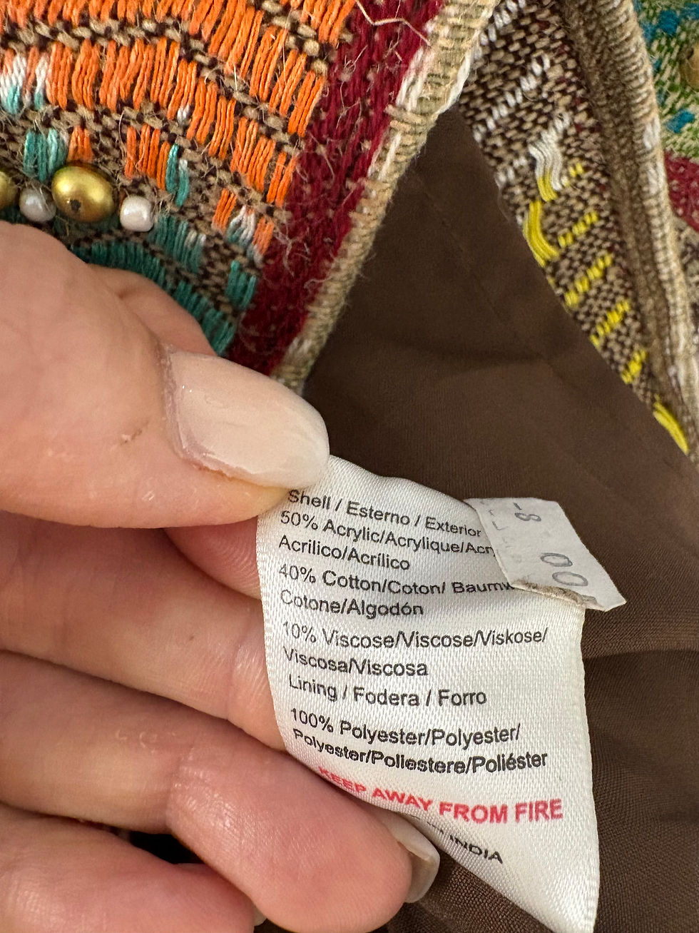 Miniaturbild: Etikett mit Text zeigt Materialien, darunter Baumwolle und Polyester, Nahaufnahme