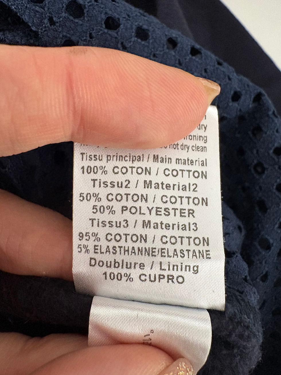 Miniaturbild: Textil-Etikett mit Angaben zu Materialzusammensetzung: 100% Cotton, 50% Polyester, und mehr.