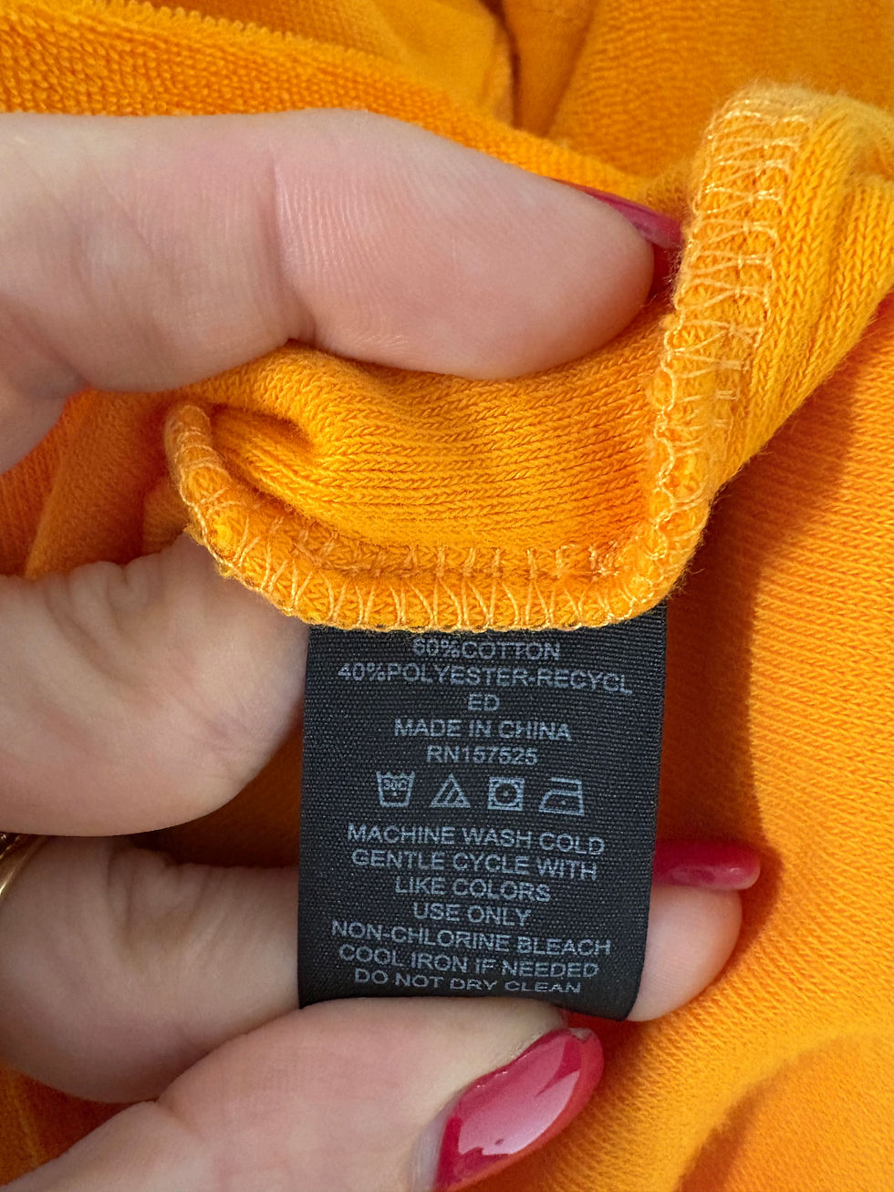 Miniaturbild: Orange fabric tag with text: 50% cotton, 40% polyester, made in China.