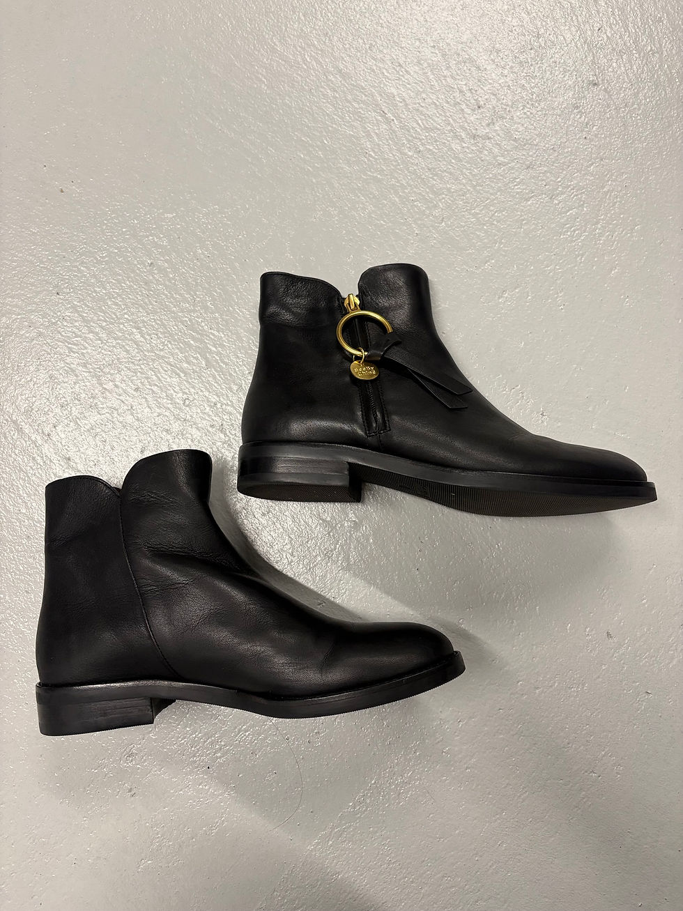 Miniaturbild: Schwarze Lederstiefeletten, zwei Schuhe nebeneinander, auf hellem Untergrund, Seitenansicht.