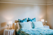 Cozy Queen bed with blue floral bedding and bedside lamps for a relaxing stay.