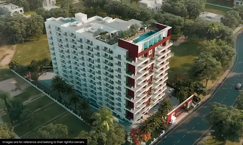 Aerial view of a modern multi-story residential building with a rooftop pool. Surrounded by lush greenery and trees, the structure stands next to a road, showcasing white and red architectural elements. Notably, sustainable practices have been integrated into its design for enhanced environmental harmony.