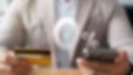 Man holding a credit card in his right hand and his cell phone in his left hand with a 0% representing low interest rate in the middle.